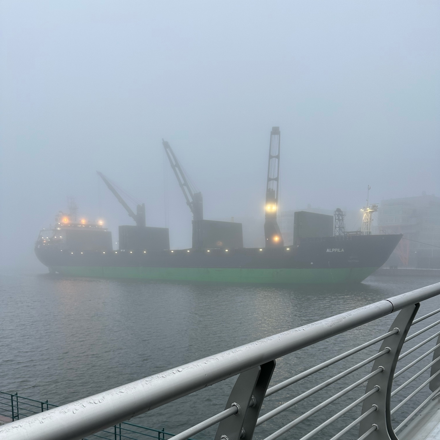 coal ship unloading on a foggy morning