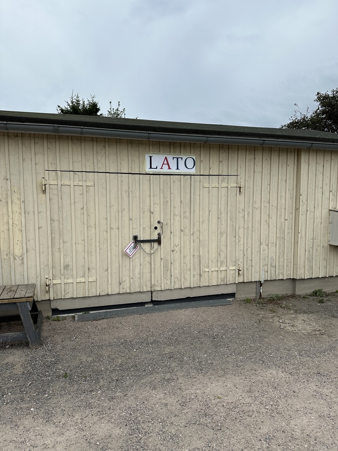 ”Lato” writtten in a serif font over a barn door. ”Lato” is a barn in Finnish, ”summer” in Polish and a popular sans-serif font