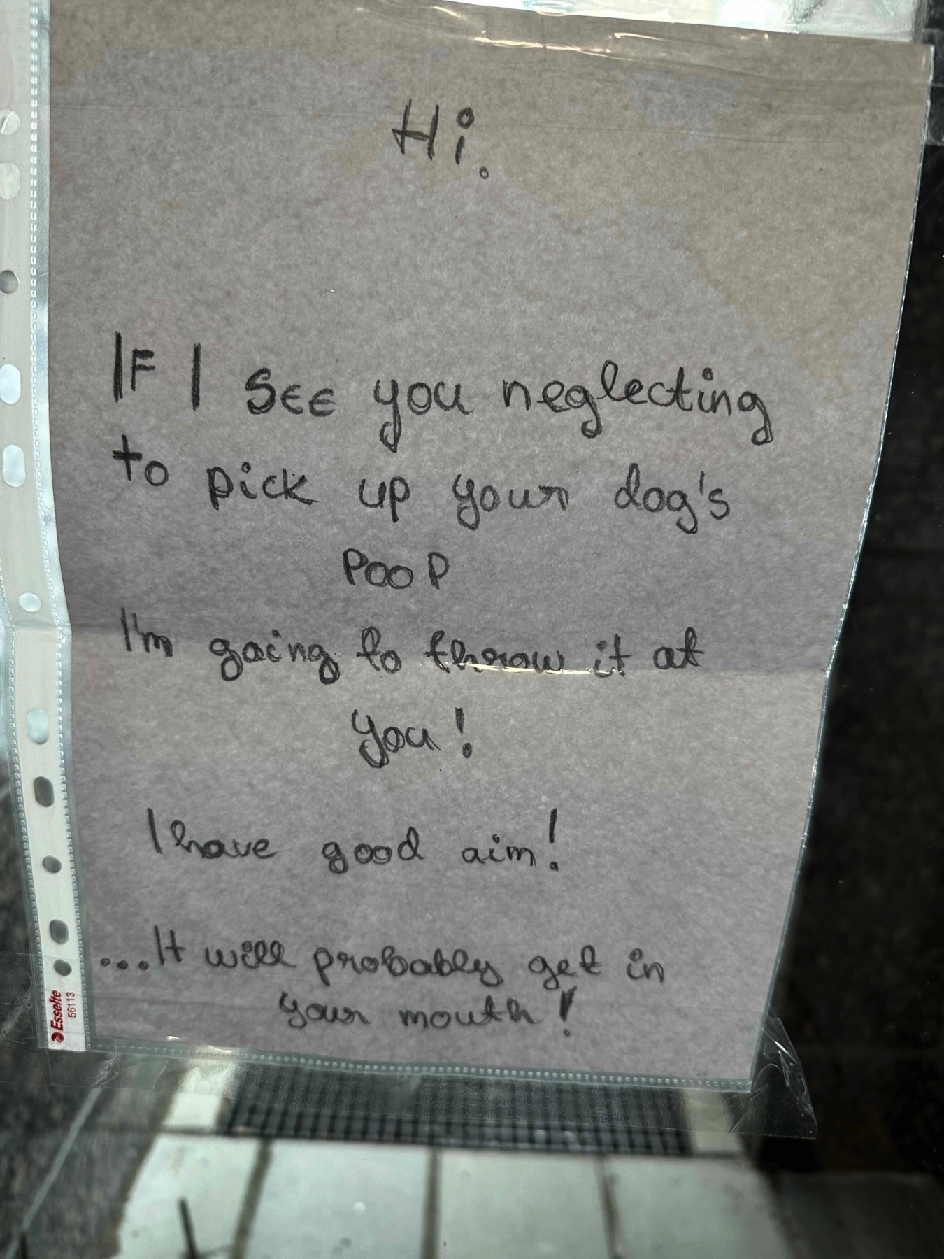 Note attached to a glass door. Note is written with a soft pencil in a delicate cursive. Note says: “If I see you neglecting to pick your dog’s poop. I am going to throw it at you! I have good aim! …It will probably get in your mouth!”
