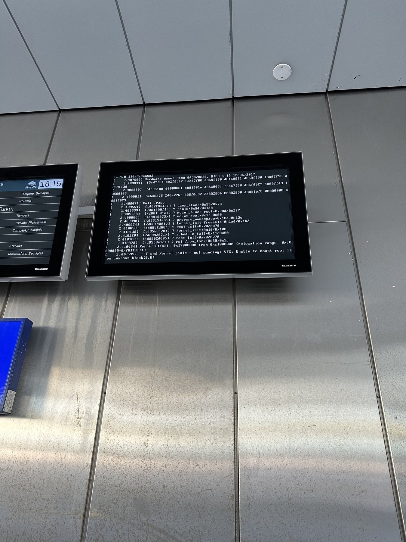 A information display hanging on a wall showing a kernel panic stack trace with ”mounting of virtual file system failed”-error message