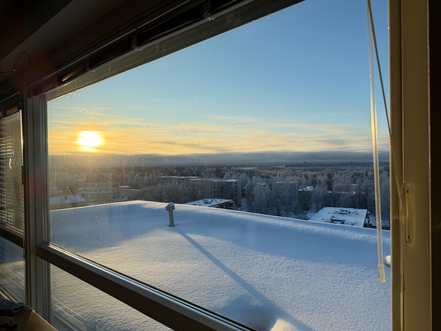 Same view after the sunrise. Snow, roofs trees