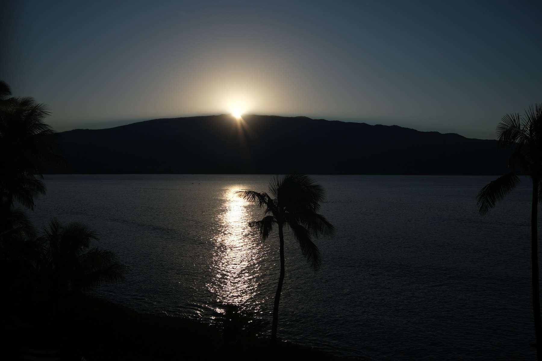 Sunrise just occurring at a silohetted Haleakala, a sudden mova of brightness.