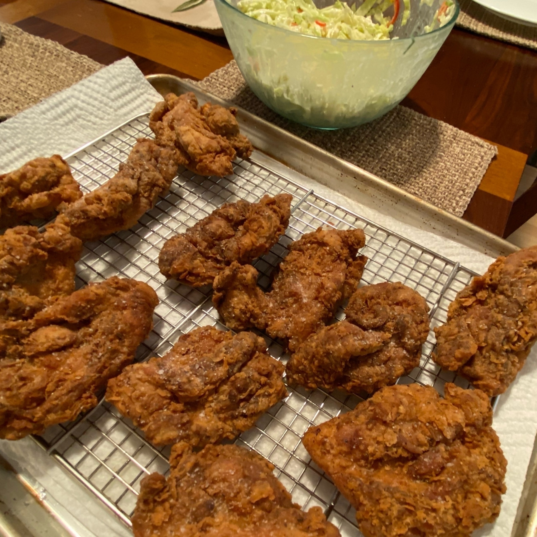 fried chicken on a baking sheet with slaw to the side (slaw has ripe red Santa Fe pepper slices).