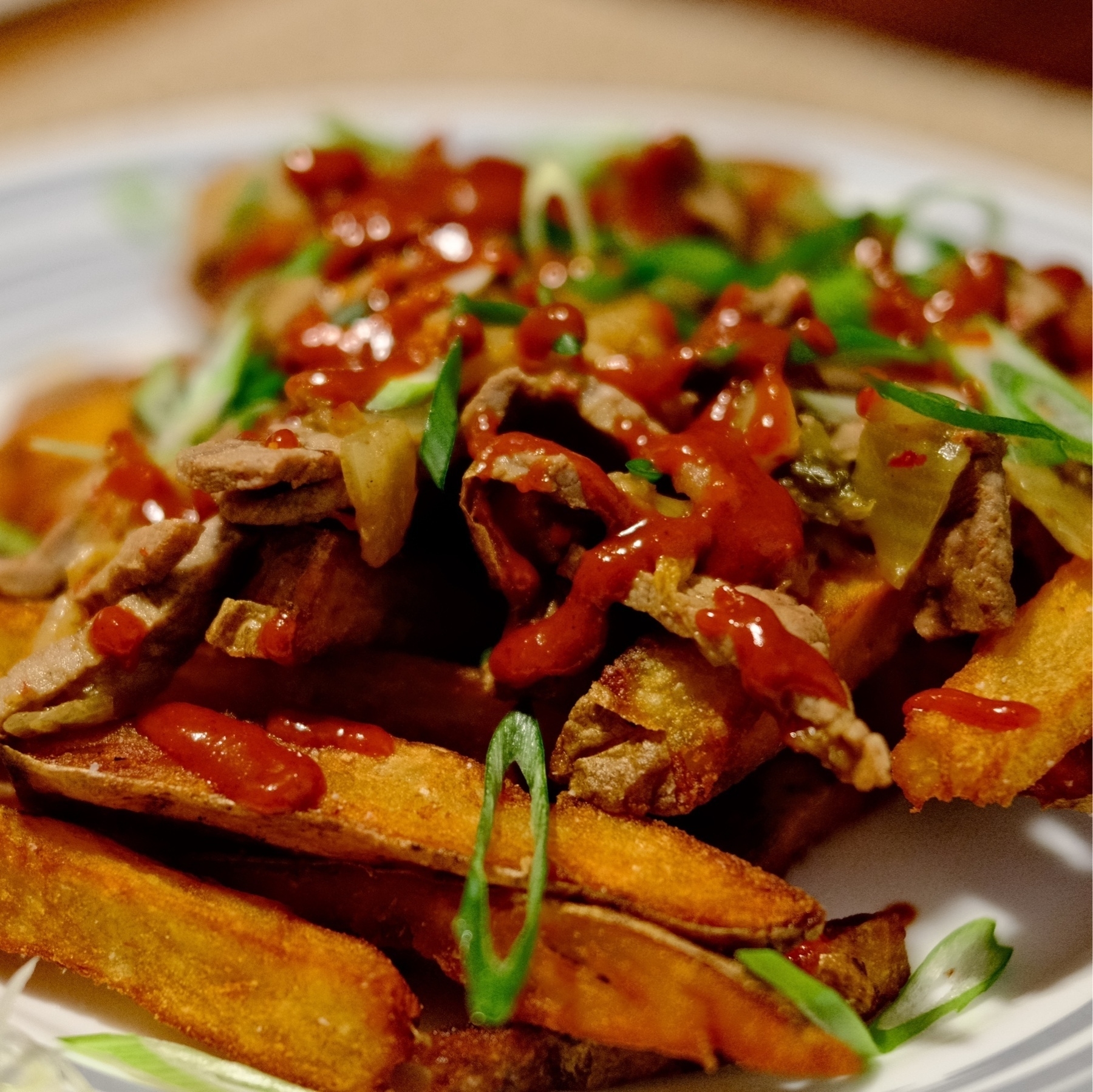 golden fries with sliced Bulgogi (marinated steak), red gochujang based sauce, topped with chives.