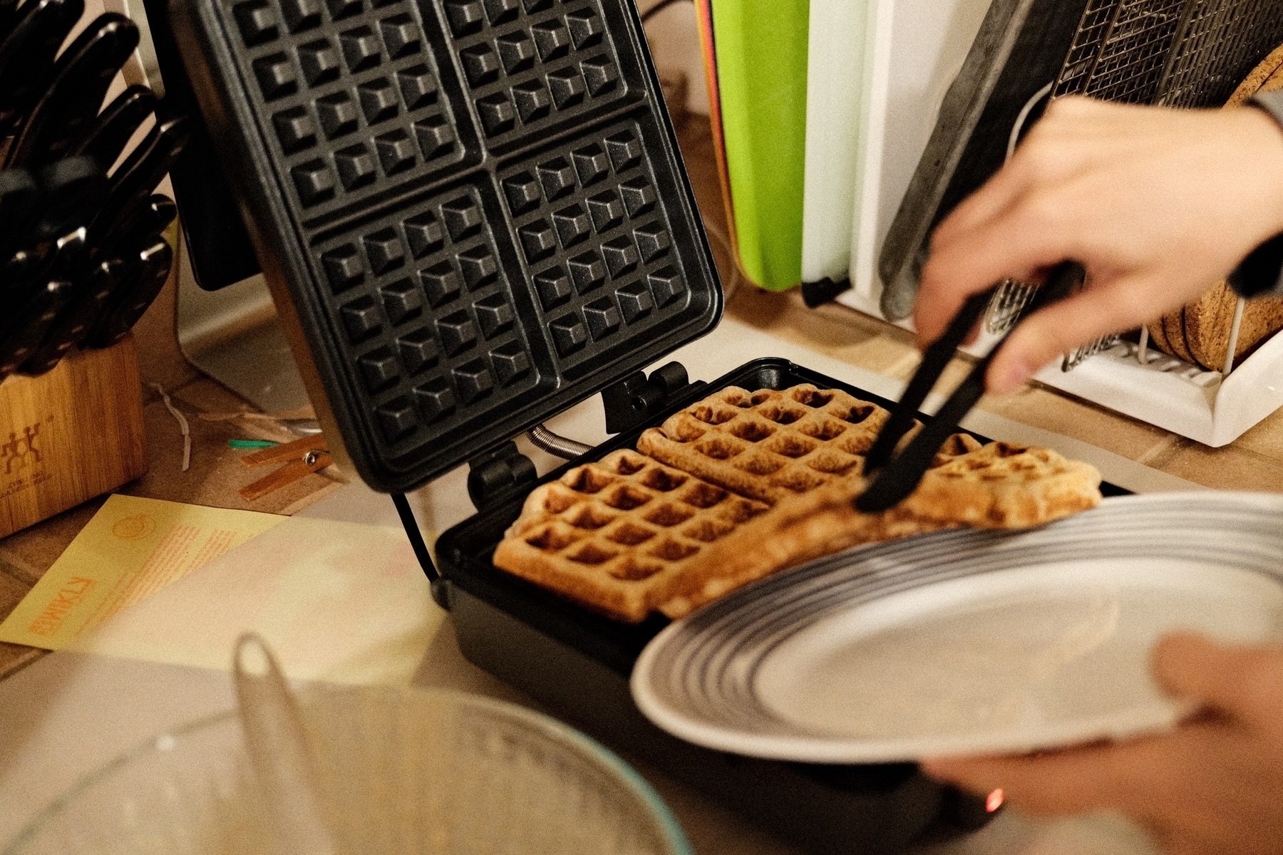 a just cooked golden brown waffle being extracted from the waffle maker