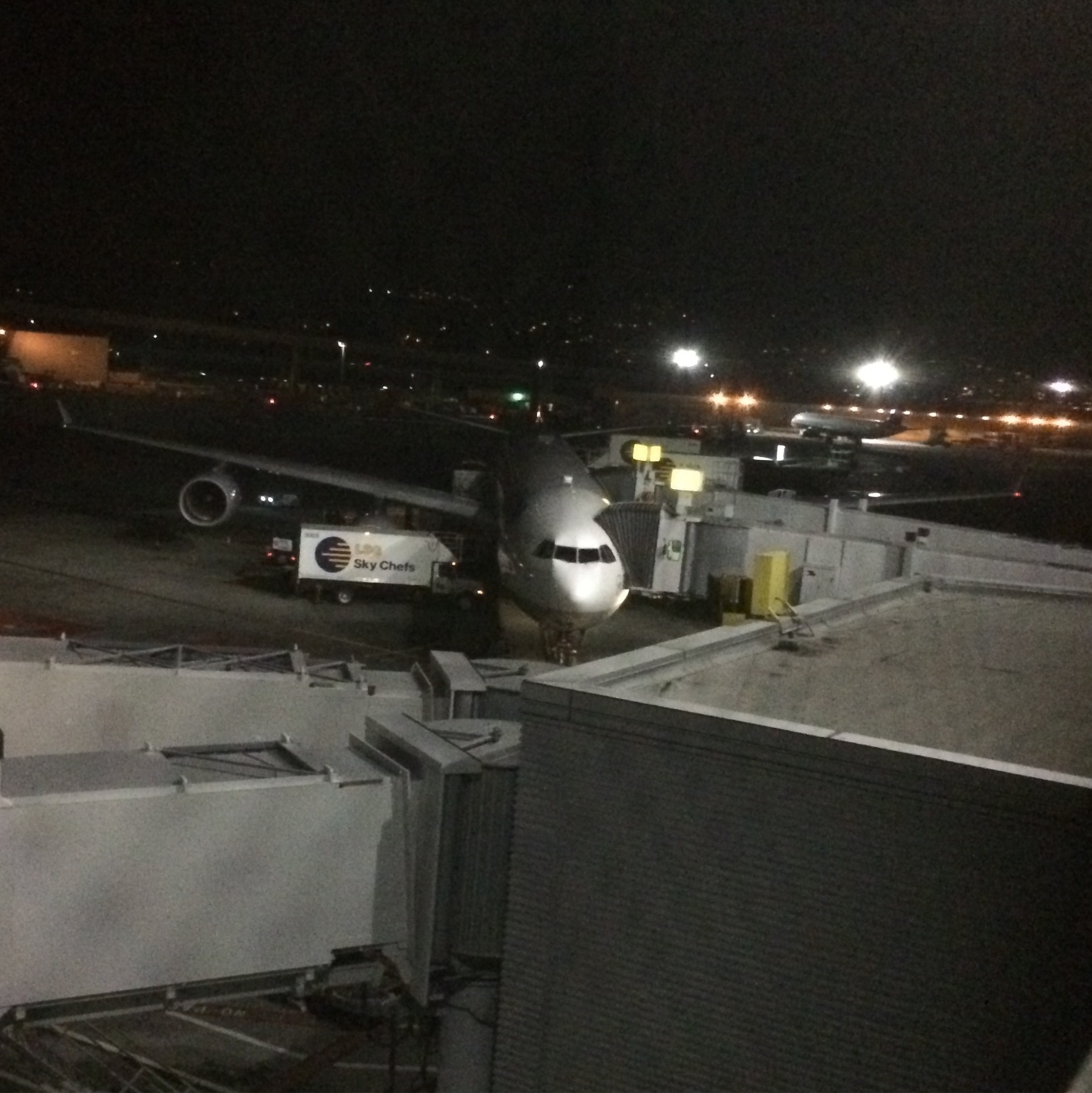 SFO gate view of a Lufthansa A340-600. Its night & the craft is being readied for boarding.