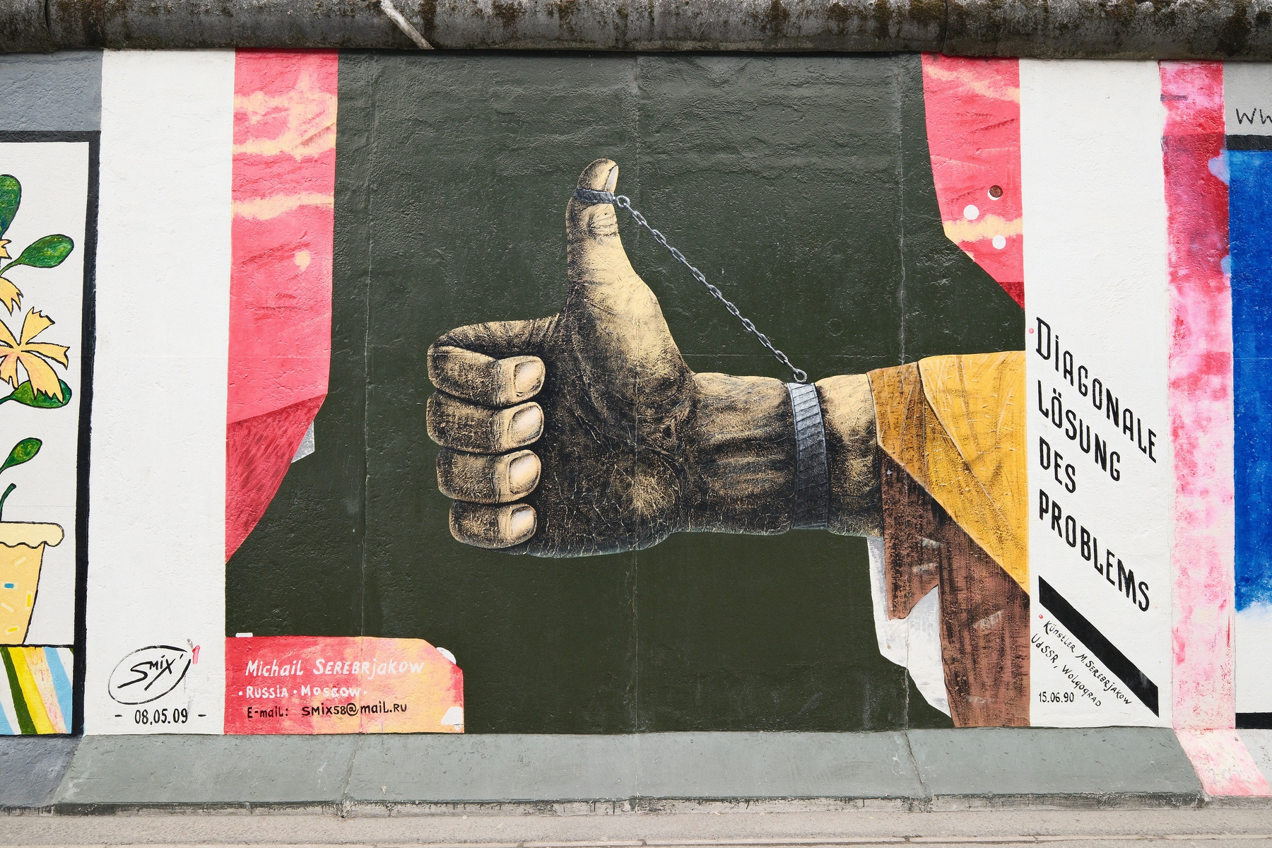 DSCF9877.JPG A mural on the Berlin Wall wall. A hand with a thumbs up and a chain attached to the tip of the thumb and onto the wrist. It is captioned with "Diagonale Lösung Des Problems" (in English, that's "Diagonal solution of the problem". The artist is Michail Serebrjakow, from Moscow, Russia.