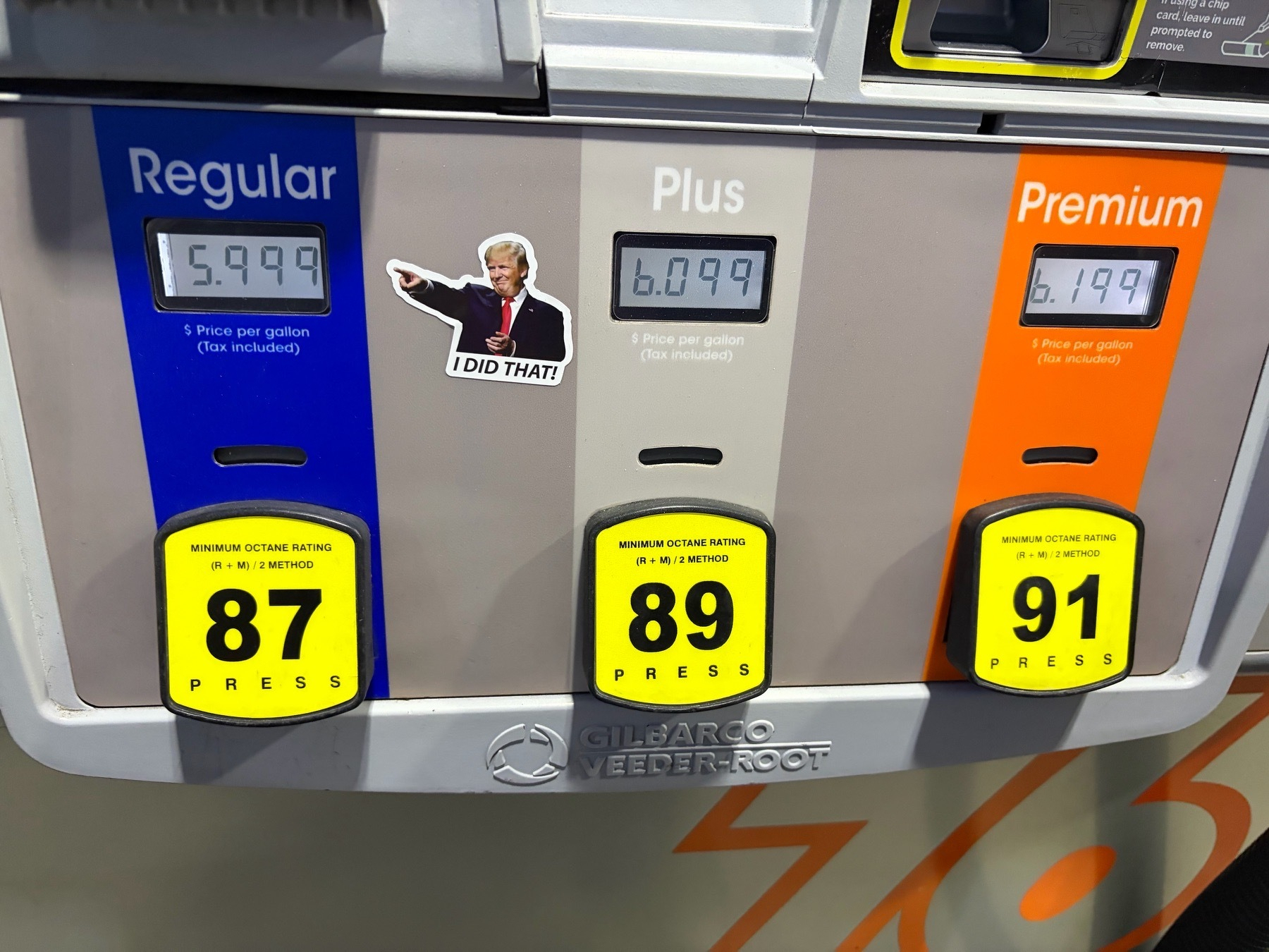 A gas pump panel with a sticker of Trump pointing at $5.99/gallon regular gasoline and saying “I did that”
