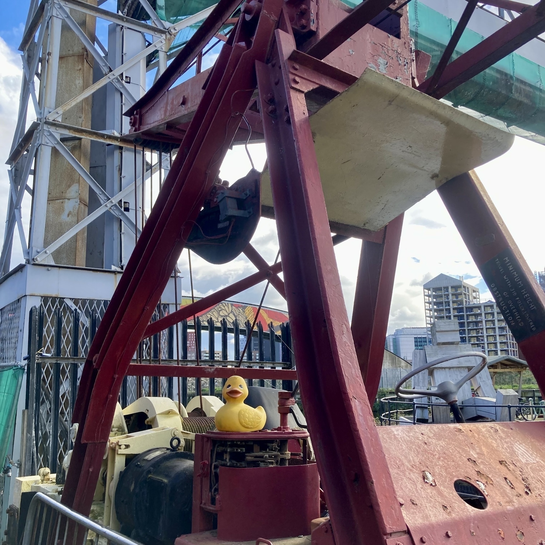 A yellow toy bathtub duck sits on a pre-war red-painted cast-iron crane at Cody Dock