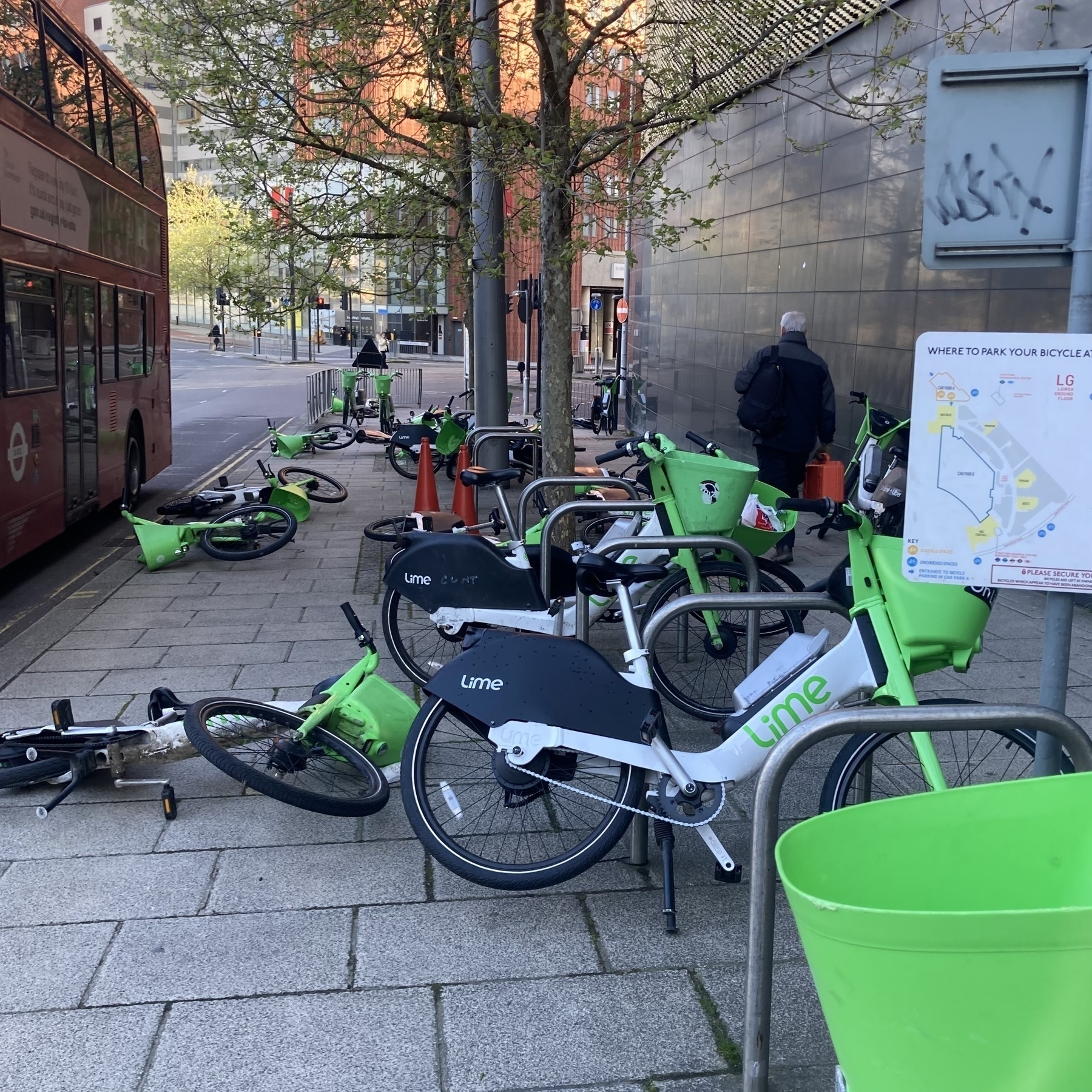 Bright green Lime e-bikes parked haphazardly or scattered on the pavement