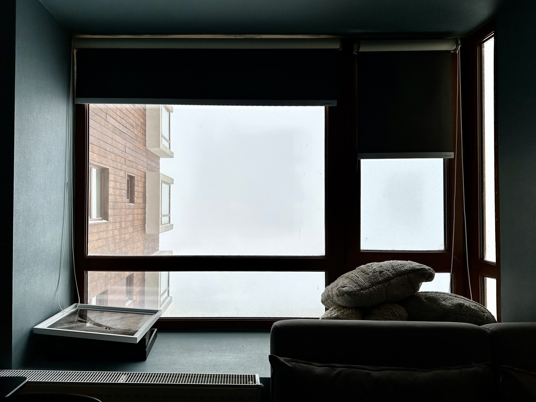 Picture of an apartment window looking out onto whiteout conditions due to snow.