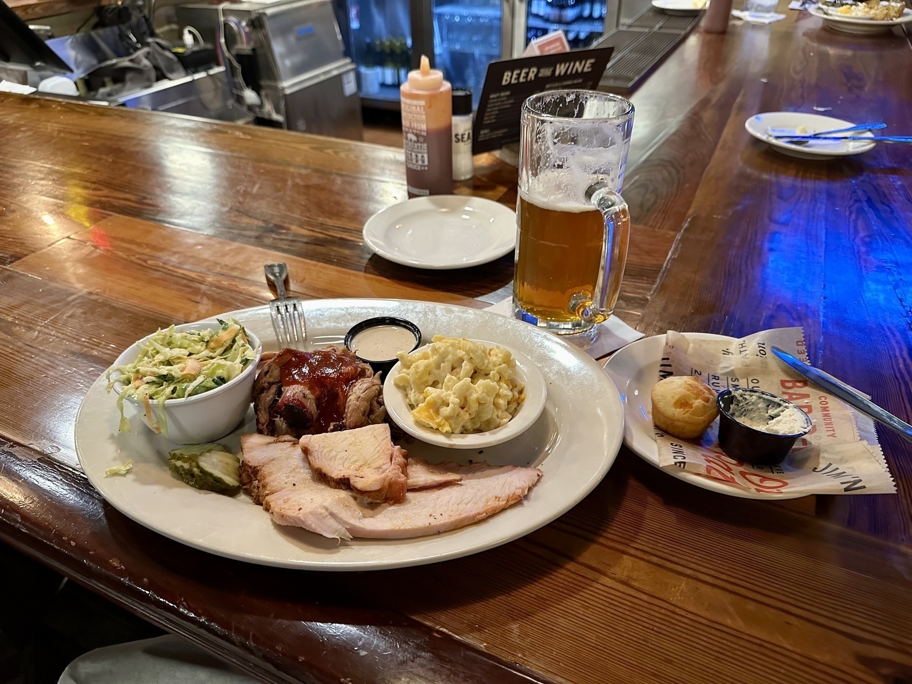 Plate on a bar with pulled pork, smoked turkey, cole slaw, mac and cheese. Side plate of muffins, stein of IPA. As God intended.