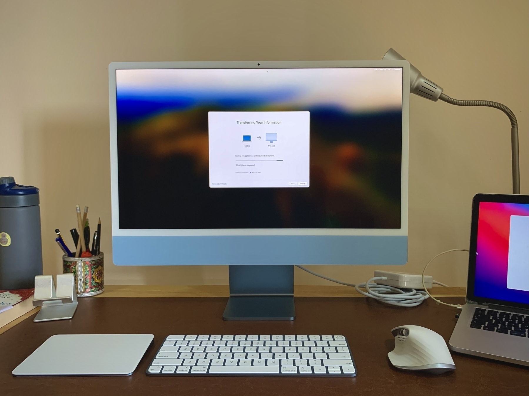 A desktop setup with a new blue iMac with a keyboard, mouse and trackpad in front of it. 