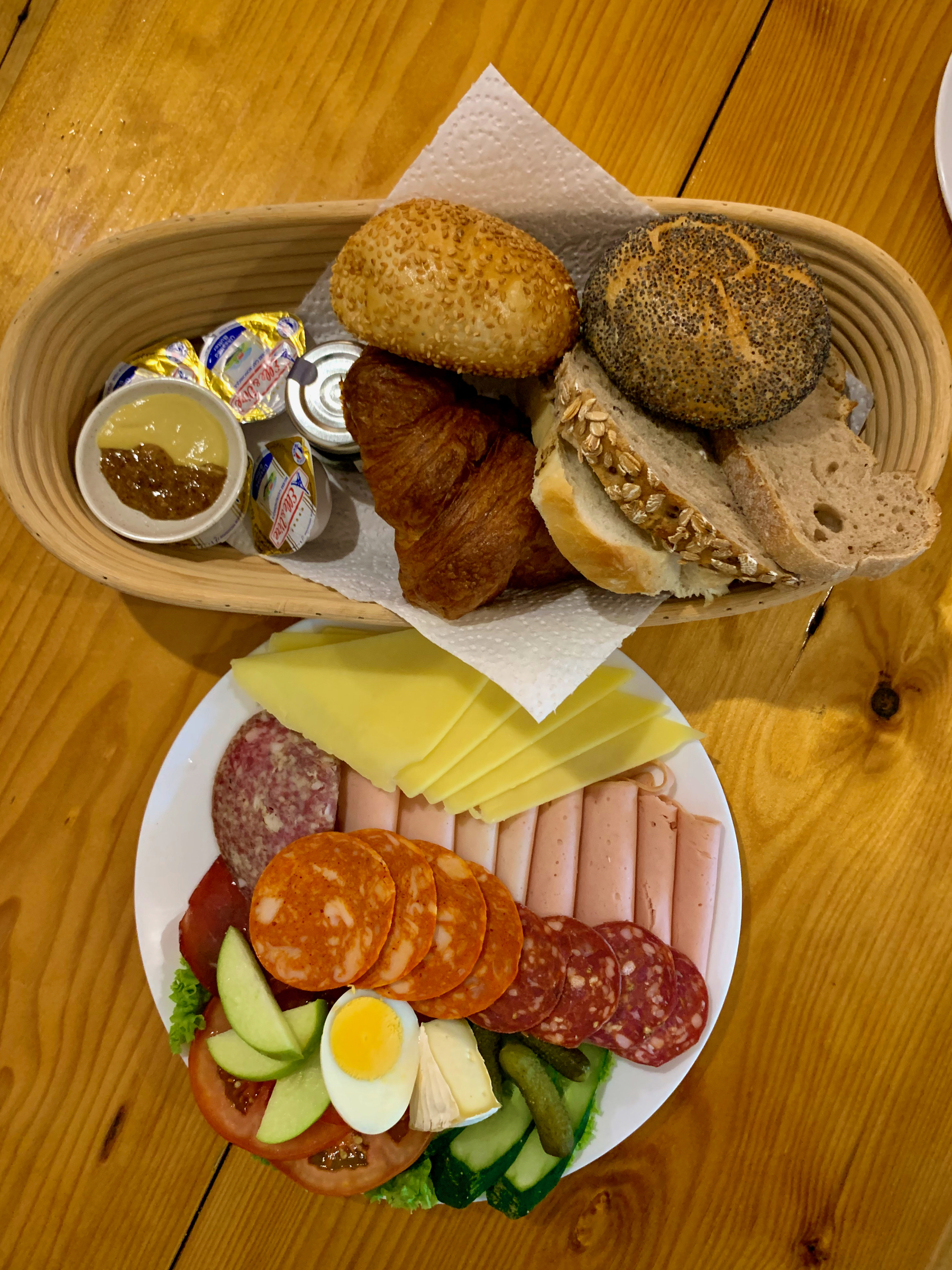  A big platter of cold cuts - ham, salami, cheese, along with a basket of breads, butter and jam