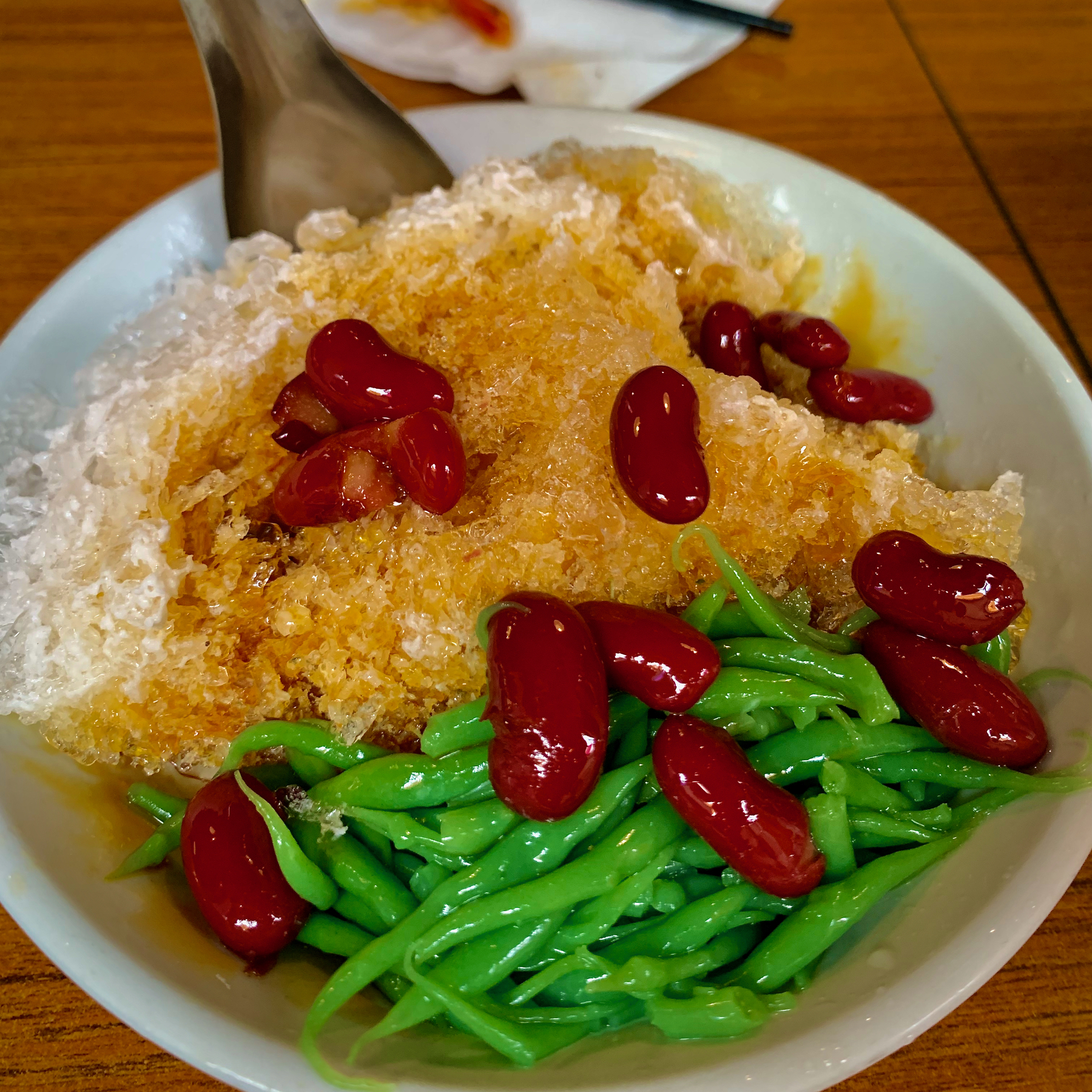 Cendol , a bowl of shaved idea topped with coconut milk, palm sugar syrup, red beans etc.