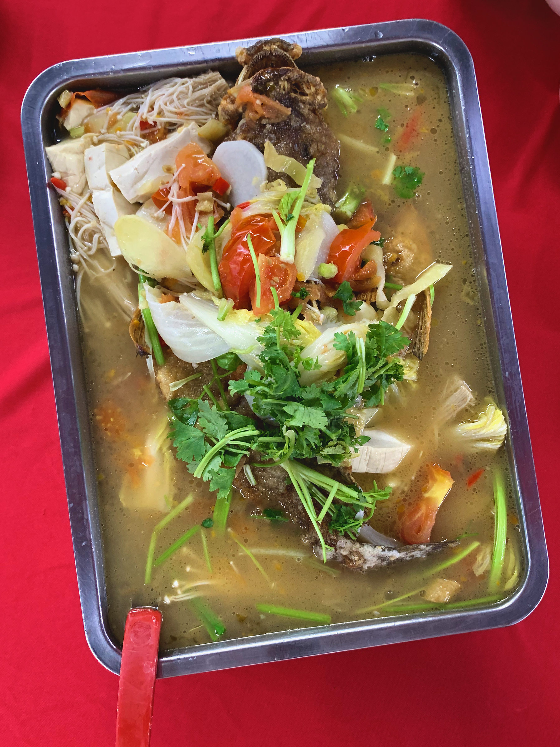 A chinese dish of whole fried fish in a broth