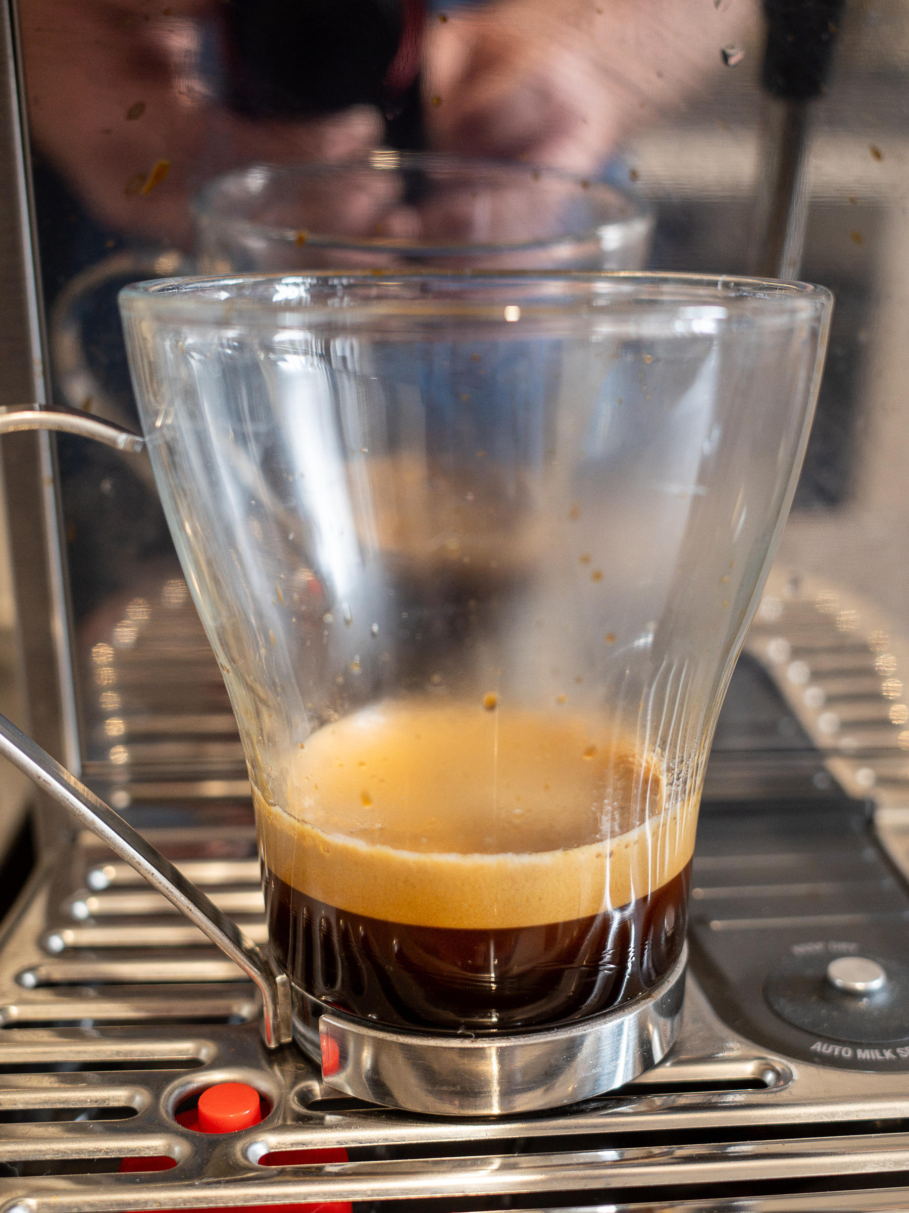 Espresso coffee with a layer of crema in a glass mug.