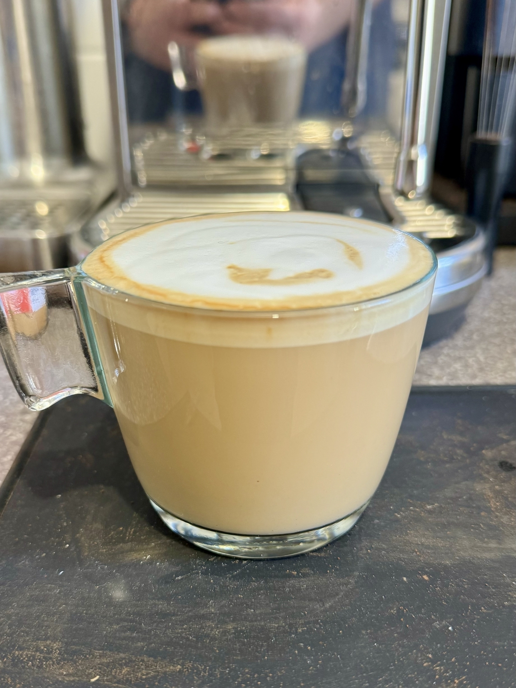 My flat white coffee in a glass mug.