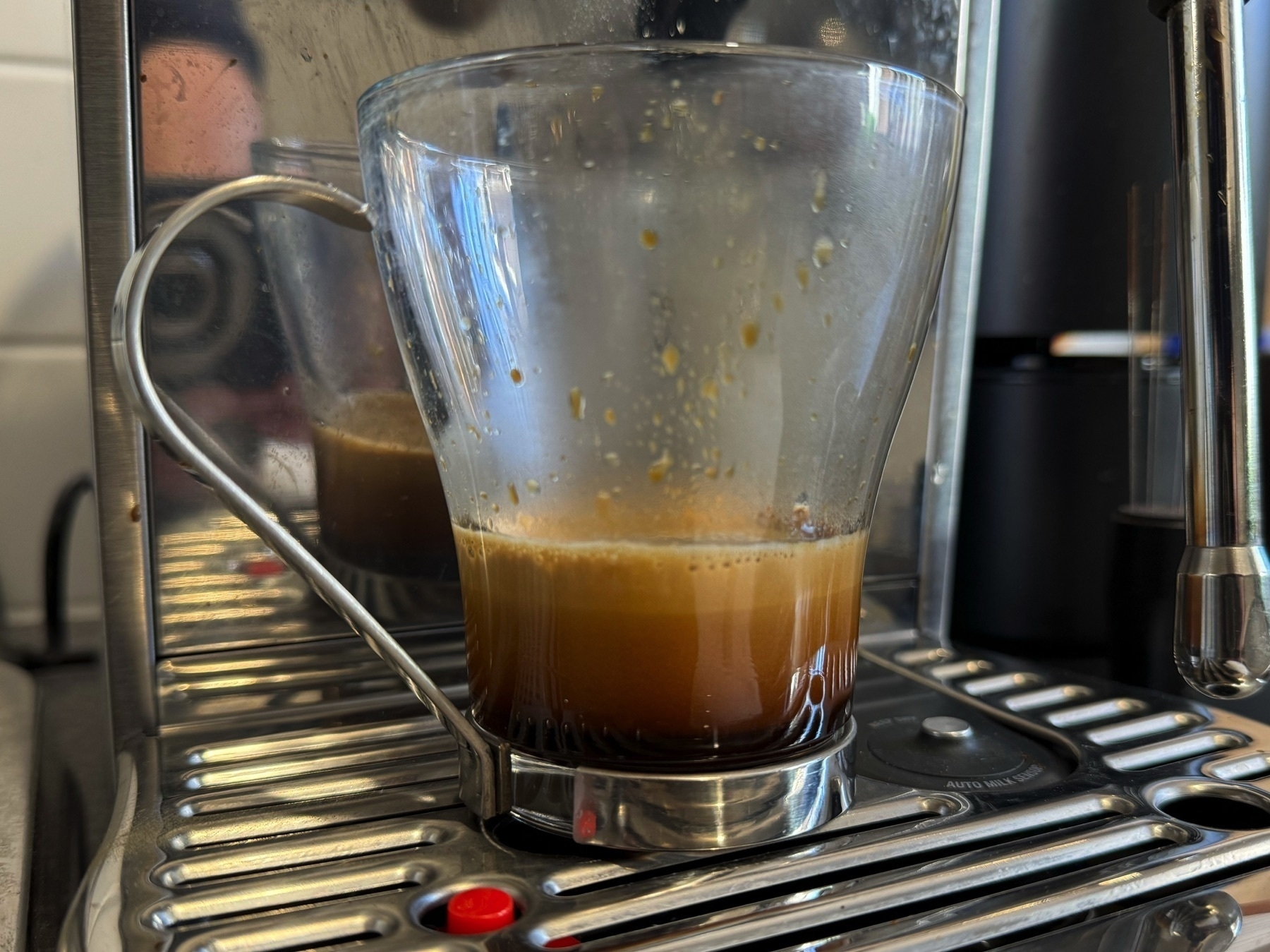 Espresso coffee settling in a glass mug.