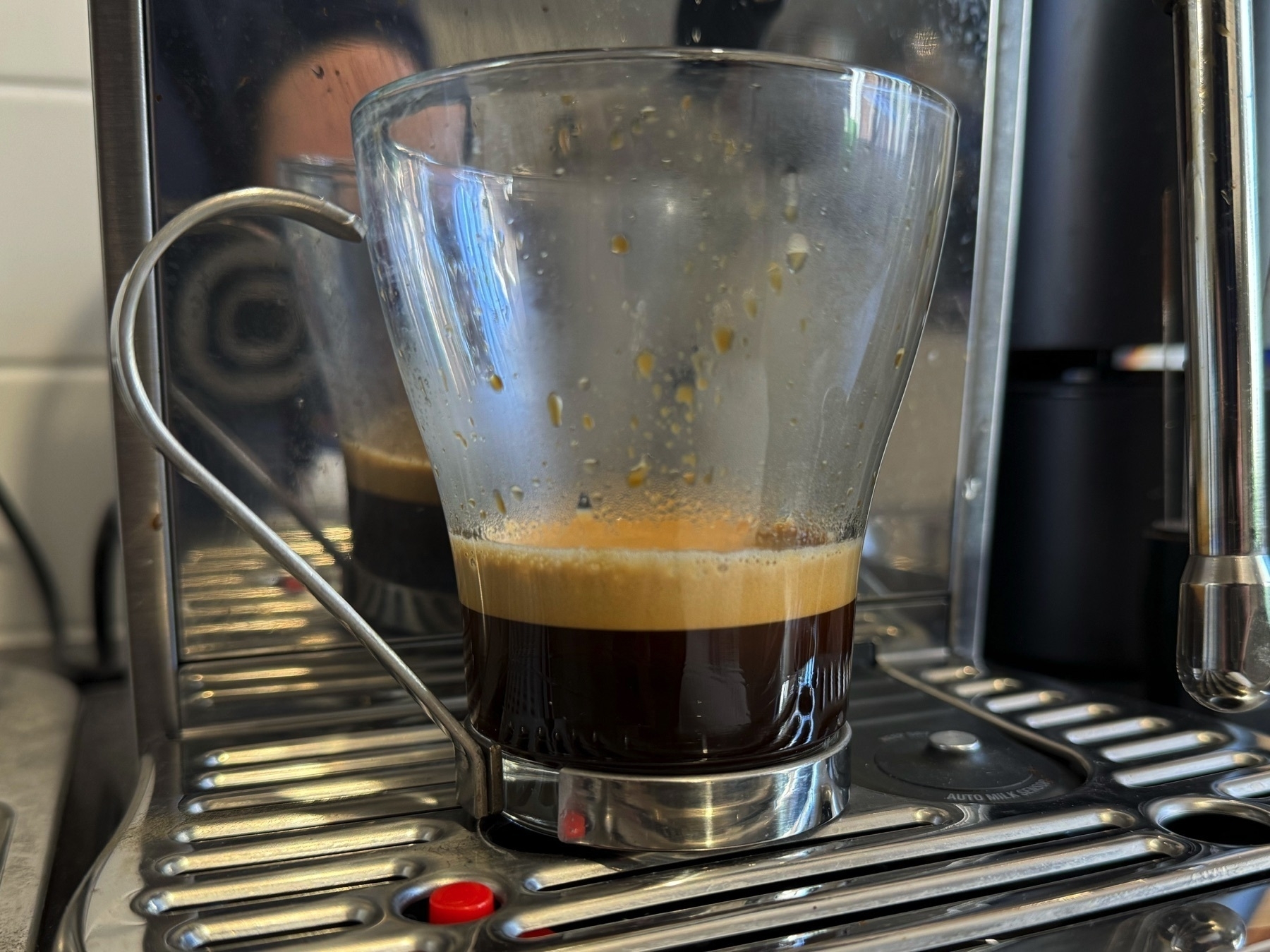 Espresso coffee with a layer of crema in a glass mug.