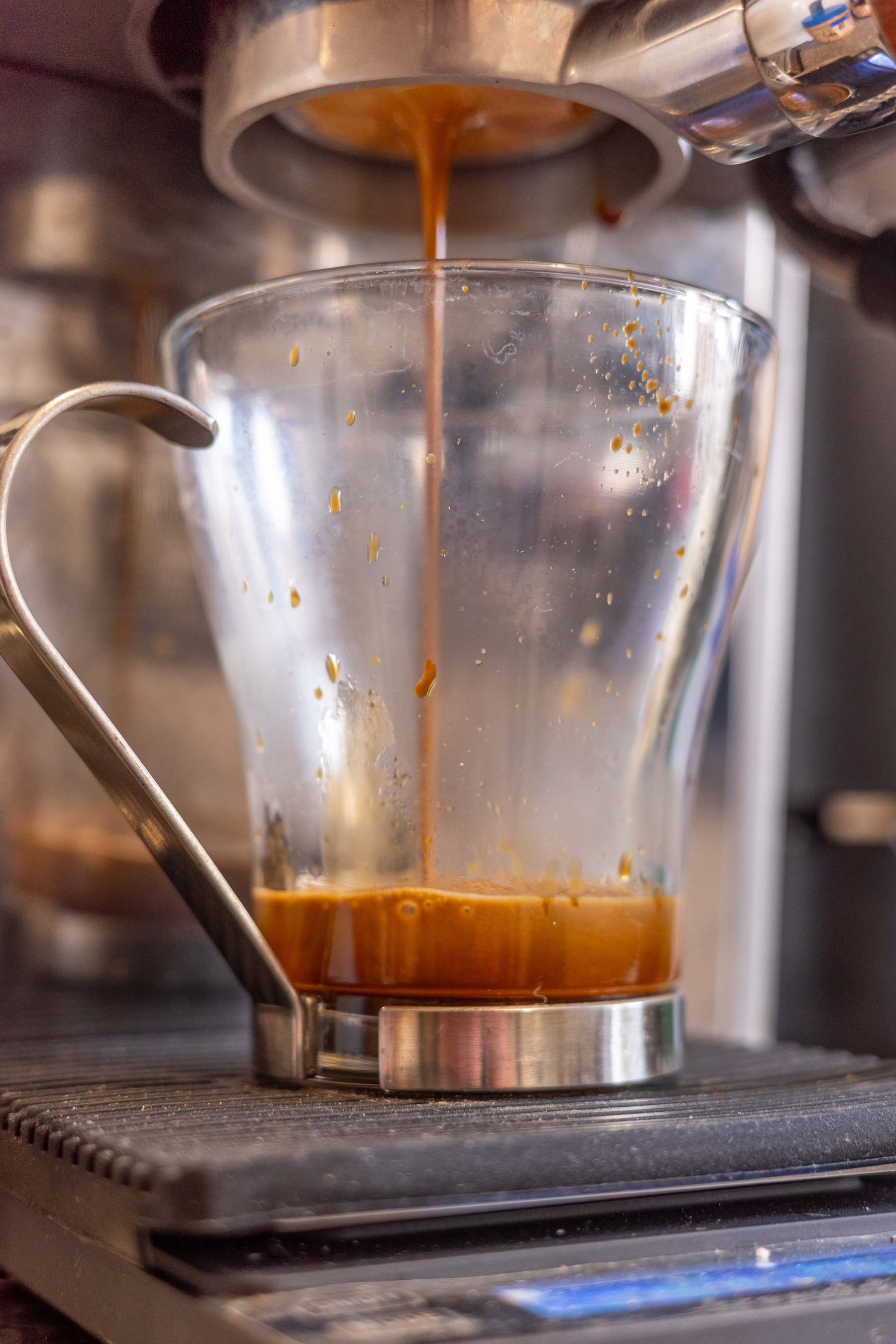 Espresso coffee being extracted into a glass mug