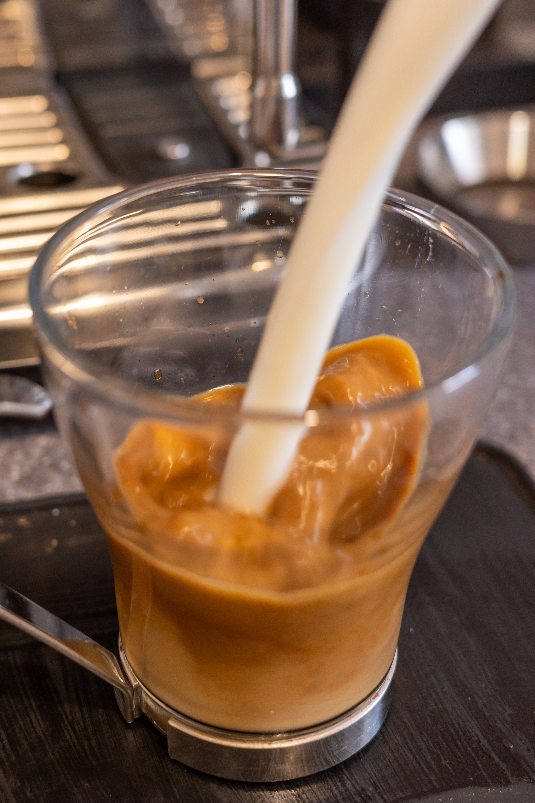 Pouring milk into espresso coffee