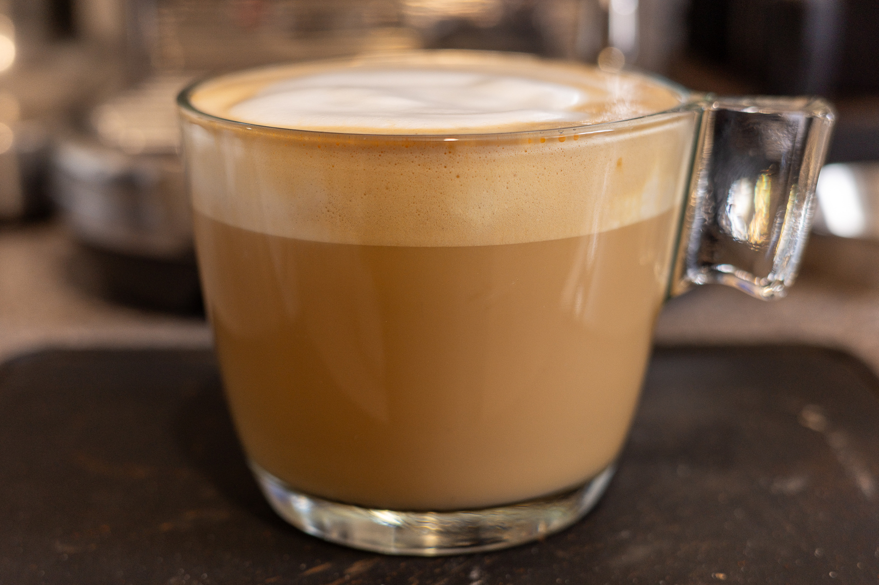 My flat white coffee in a glass mug.