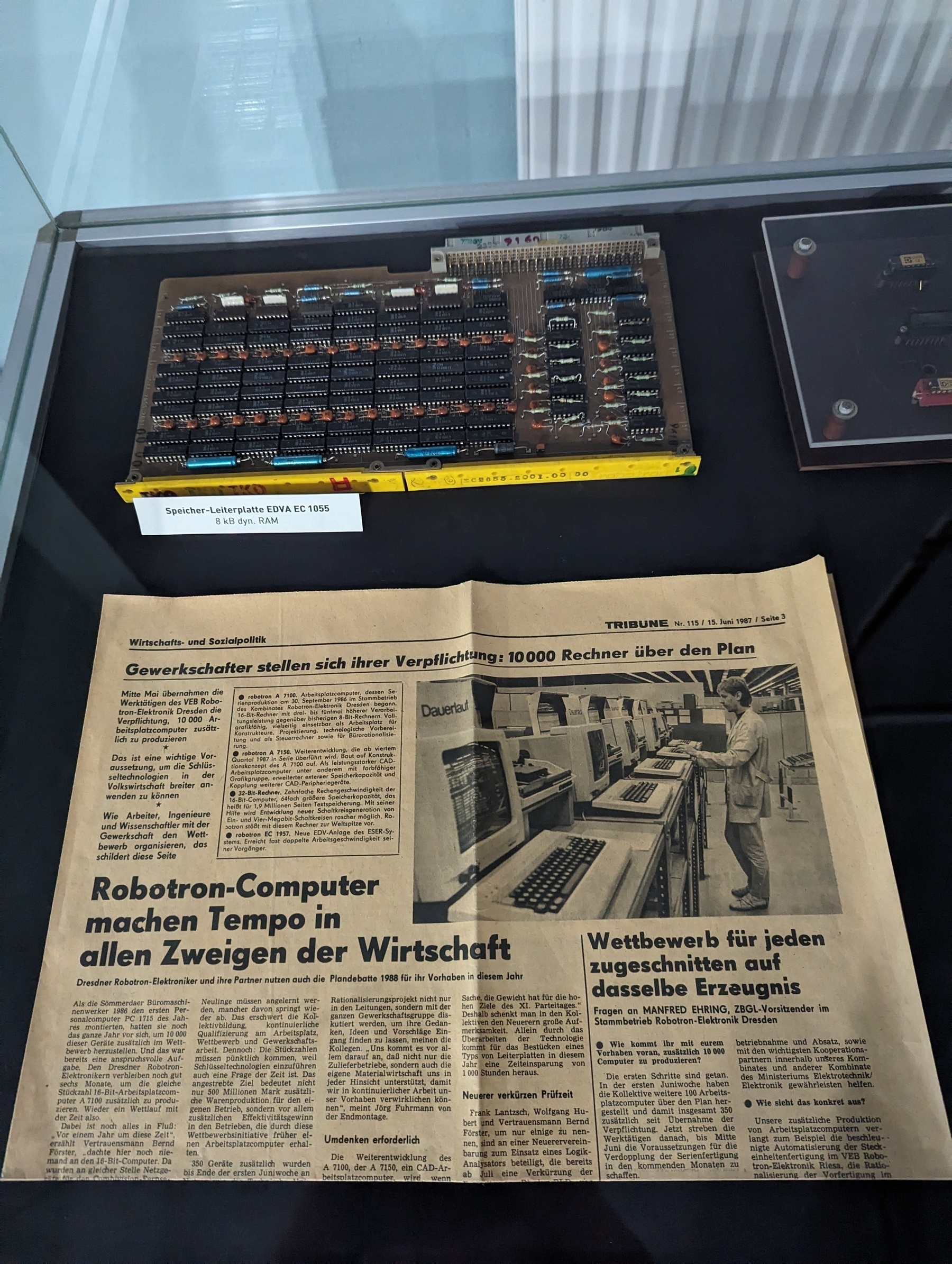 Newspaper snippet that celebrated Robotron computers in east Germany. Chips displayed on top, museum style 