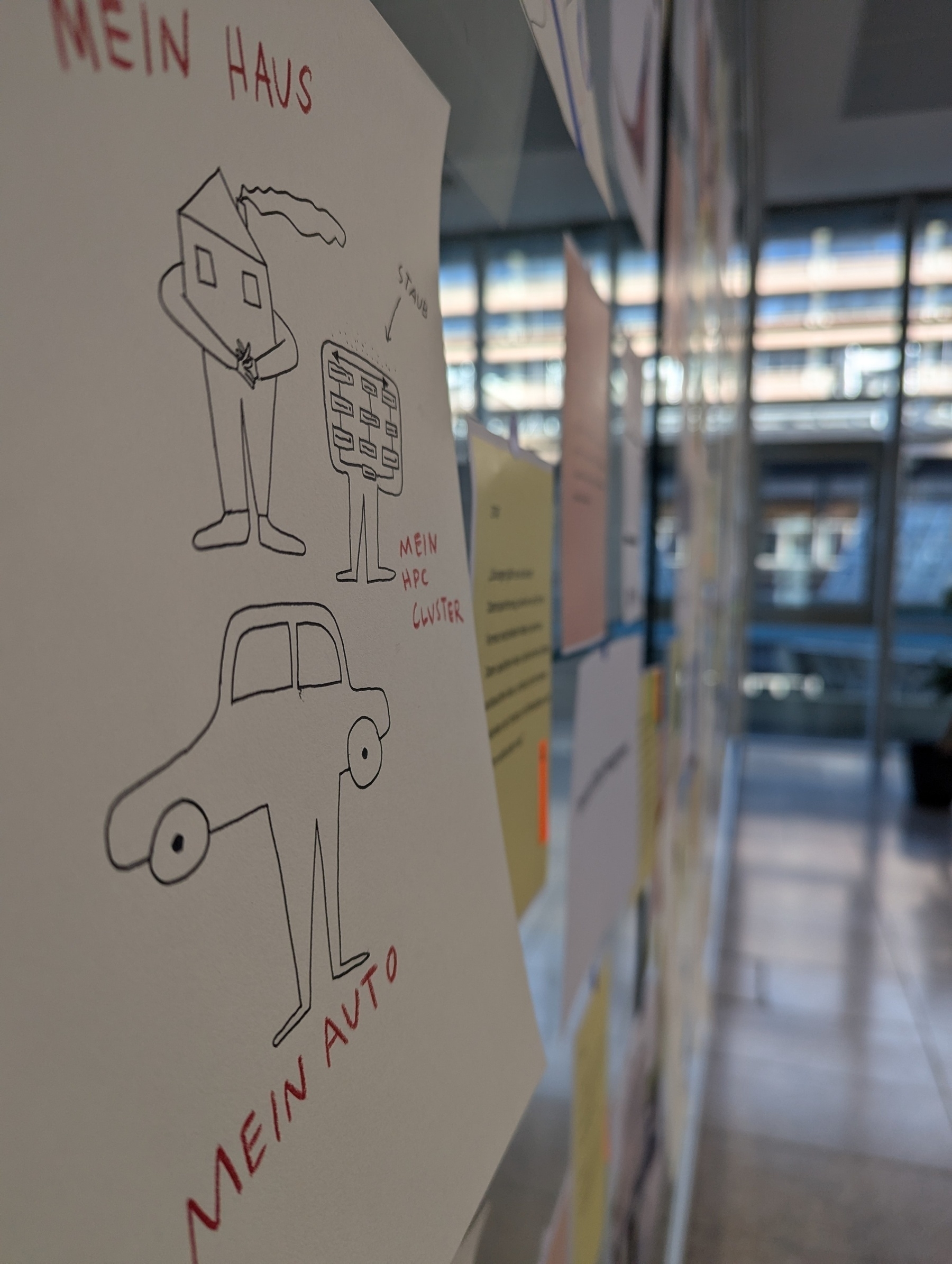 Another sneak peak at the glass wall from the side, with a focus on a comic-y rendering of one note. We had splendid support by [graphicrecording.cool](https://graphicrecording.cool) &10;&10;This note says, "My house, my car, my HPC [High-Performance Cluster]", hinting at how some professors are thinking about acquiring and using high-tech infrastructure. The comic reminds of a popular ad in Germany.