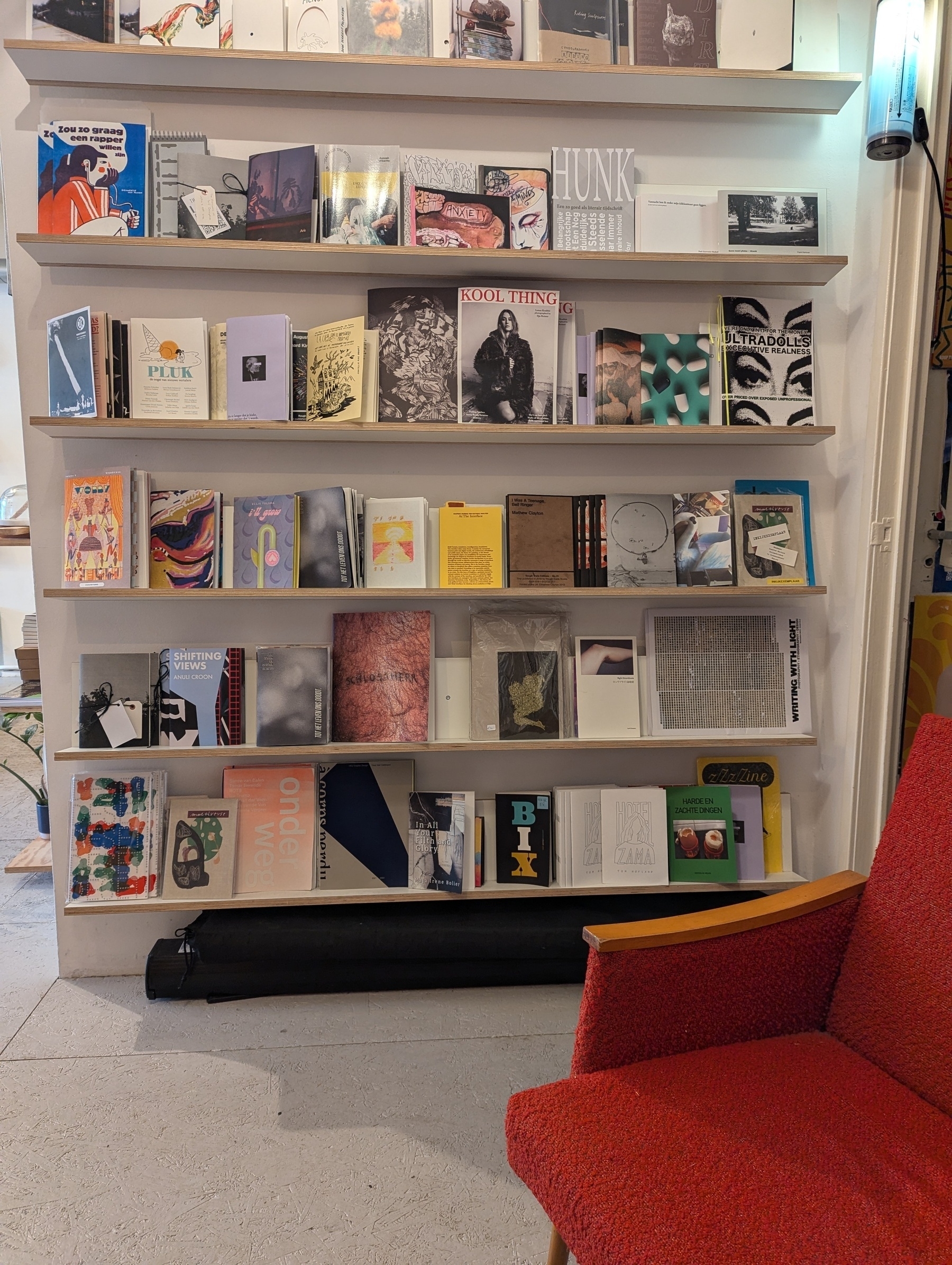 Book shelf in a book store. Colourful (maga)zines that build a nice mess. It's a lot of local and some international work, queer, artsy, lots of street photography. There's a cozy armchair in the front 