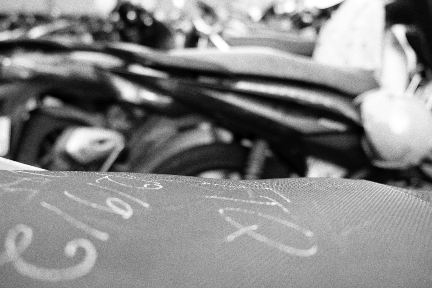 A row of parked motorbikes, with chalk notes on the seat. That's how vehicles are marked, although it's more common to write on the dashboard 