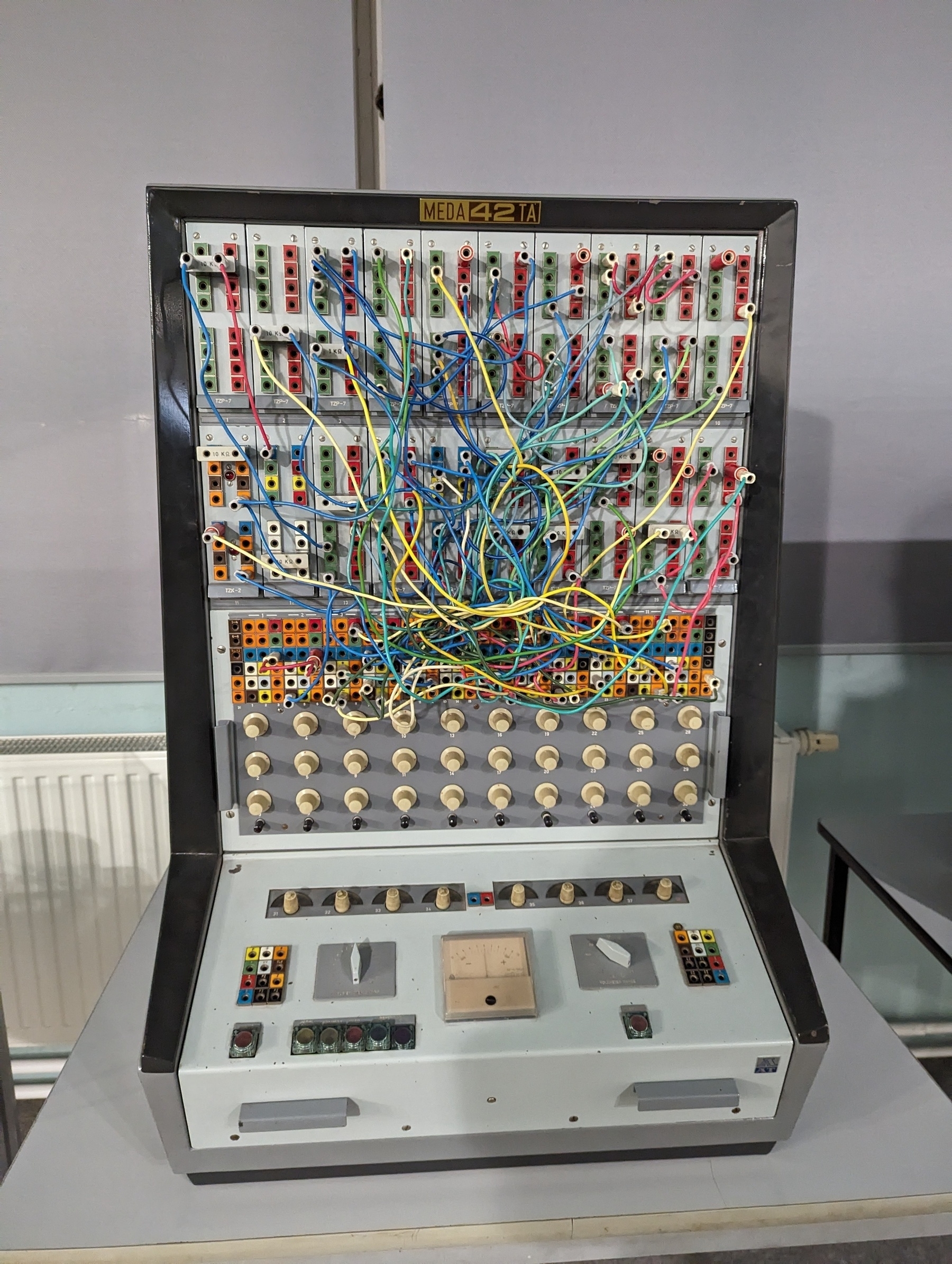 An old computer that looks like a big switch, lots of cables that were manually managed and were the computing act. A few buttons below 