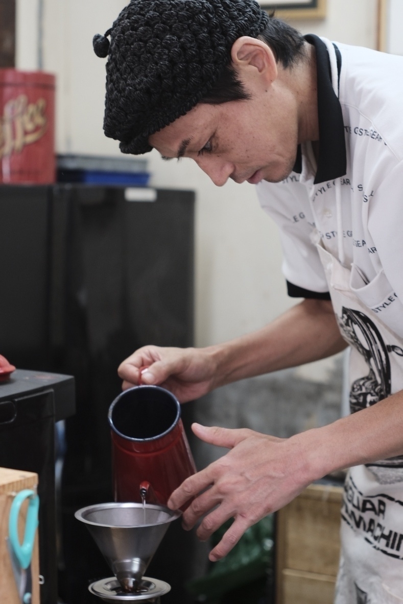 A man in a white shirt pulls a chocolate-y, wine-y coffee. It happened to be a fine Vietnamese robusta blend, still a unique sight abroad 