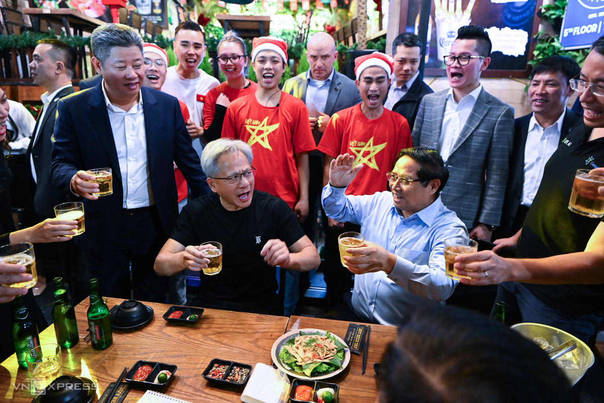 Jensen enjoys a bottle of beer and some snacks, while the Prime Minister and others around him cheer, chanting Vietnam. Copyright vnexpress.net