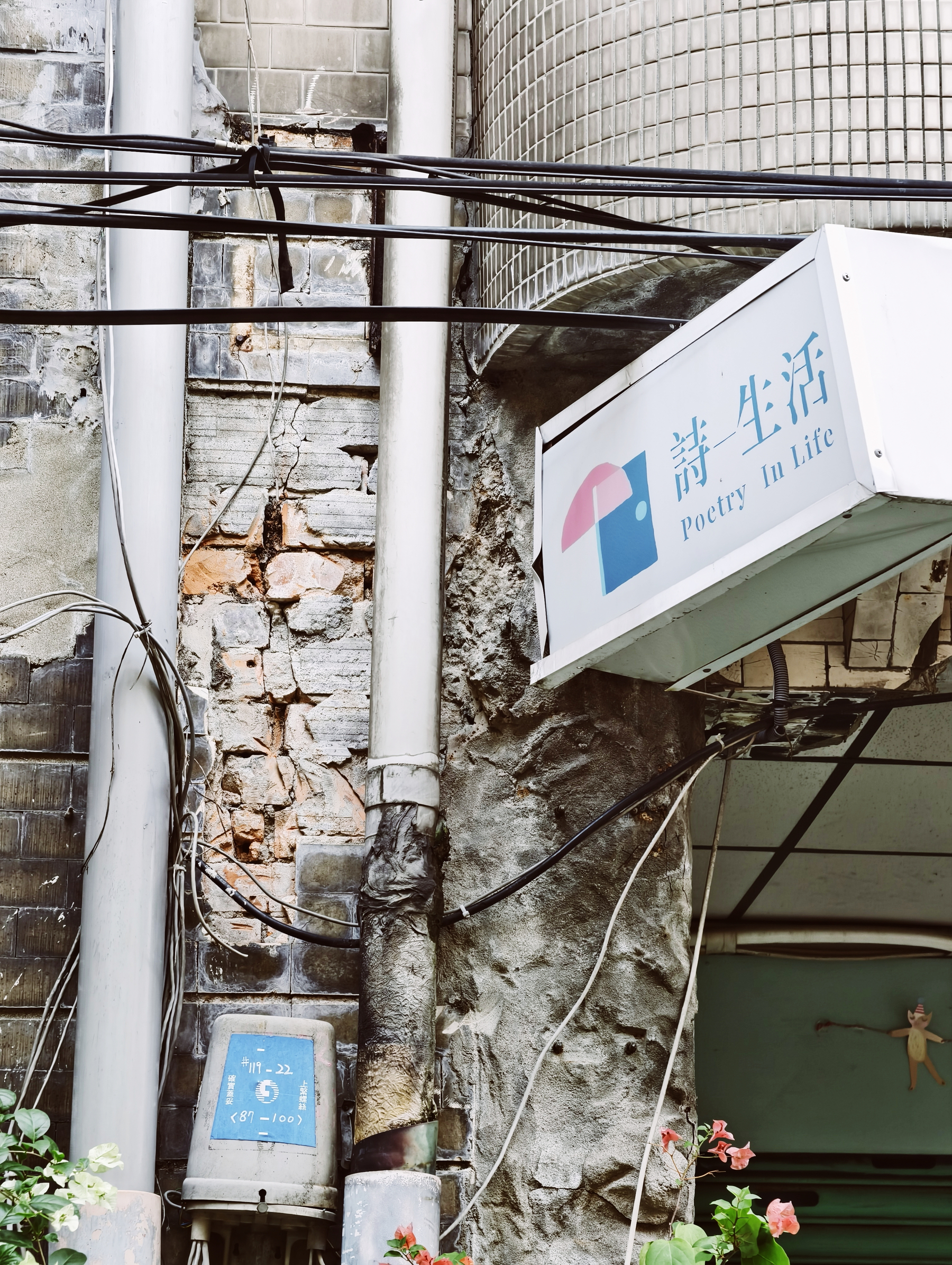 "Poetry in life," a sign for a store on a wall, a slightly broken wall; poetry in itself 