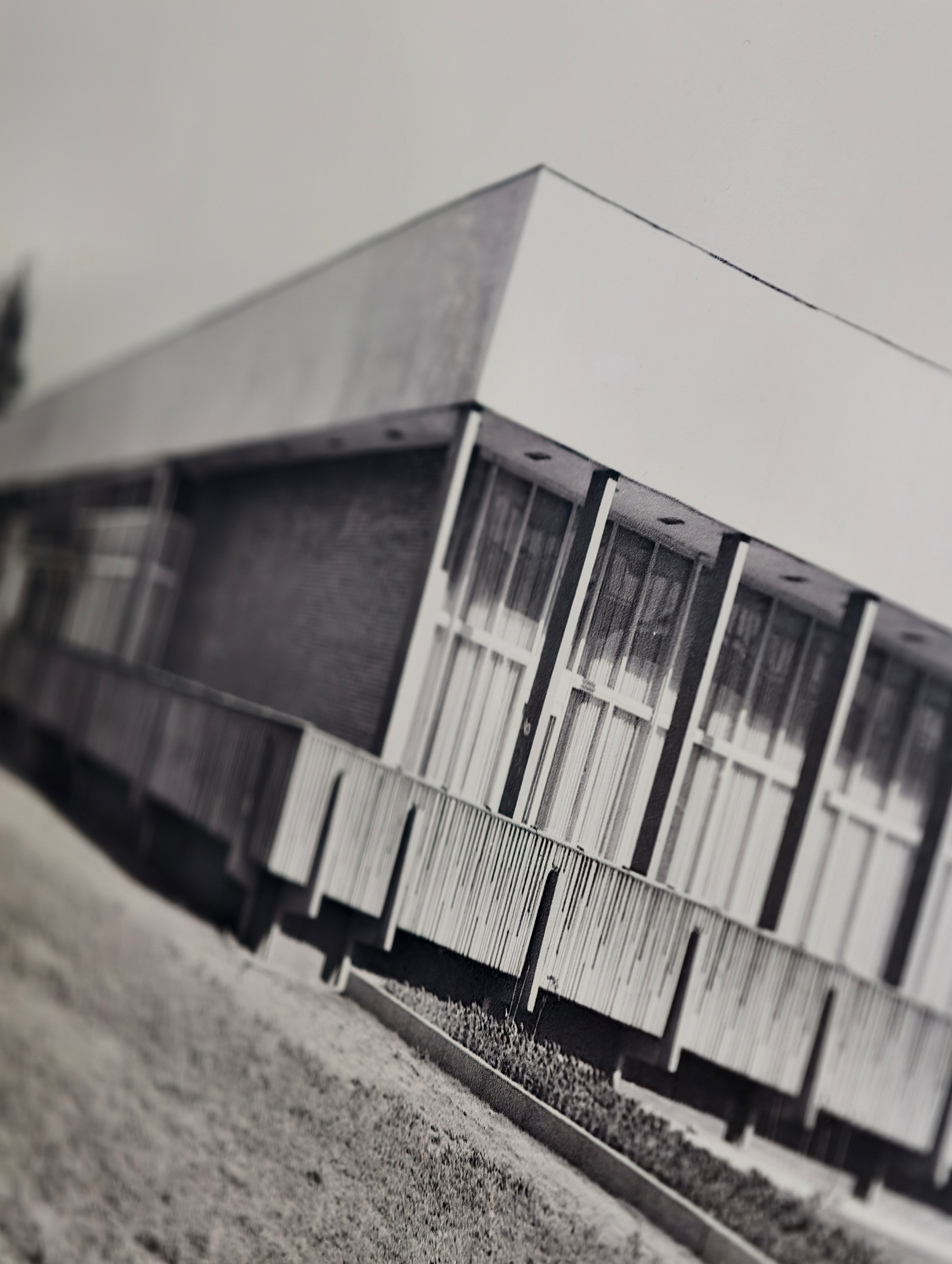 Eine S/W-Fotographie der Robotron-Kantine aus dem Jahr 1979, schief fotografiert. Ein rechteckiges einstöckiges Gebäude auf Podest