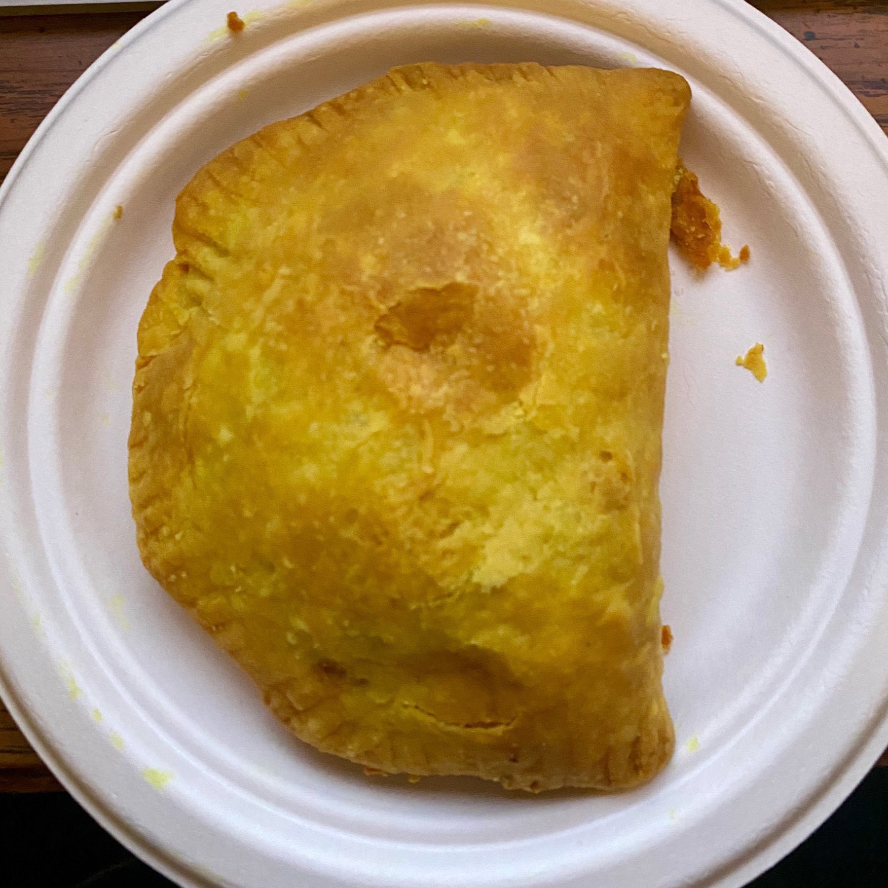 Photo of a Jamaican beef patty I made from scratch on a plate after baking.