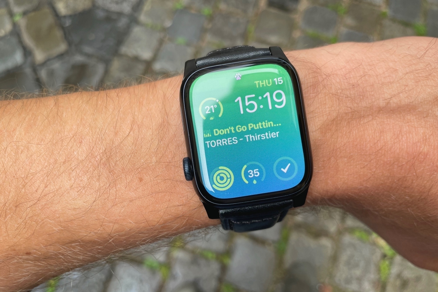 Arm wearing an Apple Watch with Modular face and a green to blue gradient background