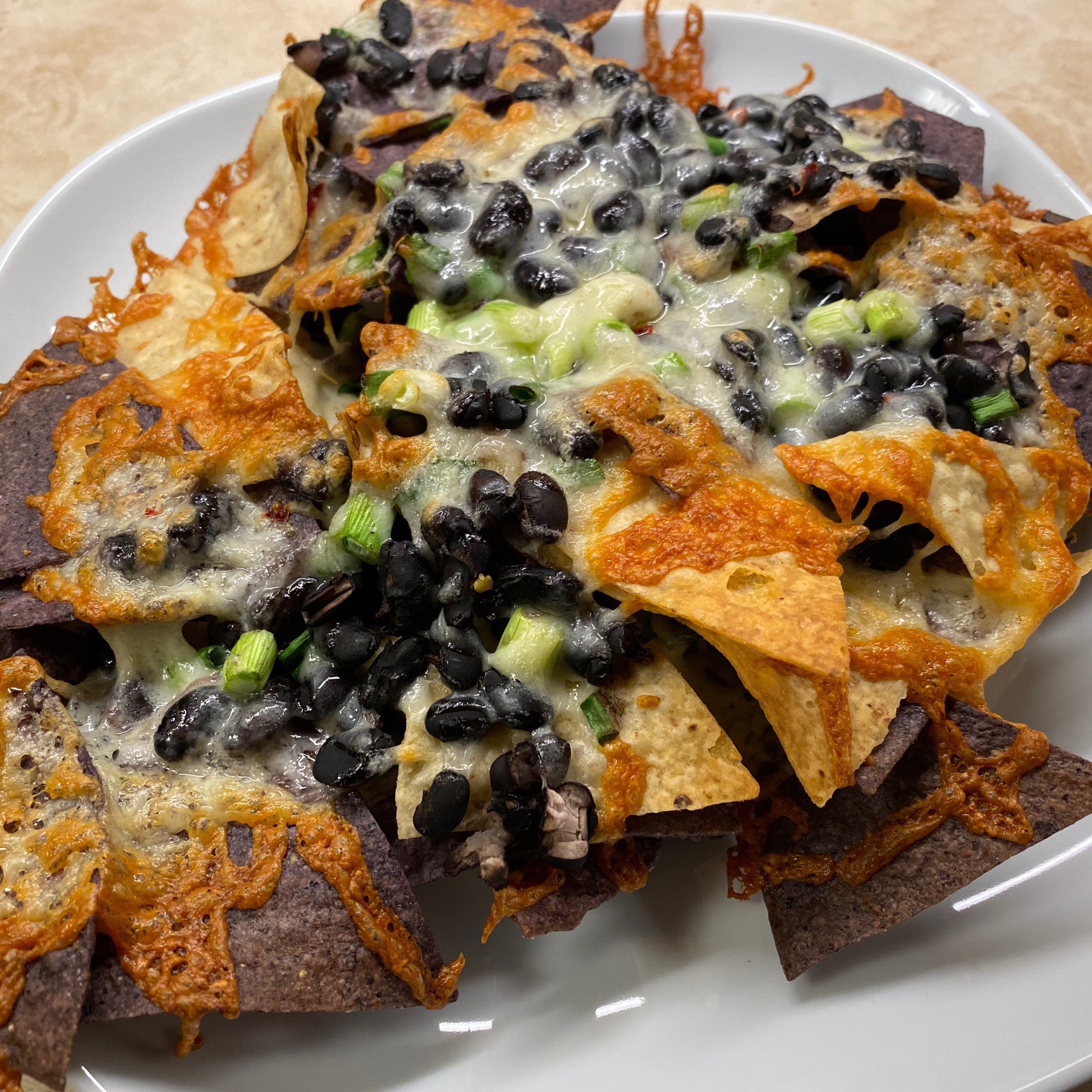 Nachos with black beans and cheese on plate.