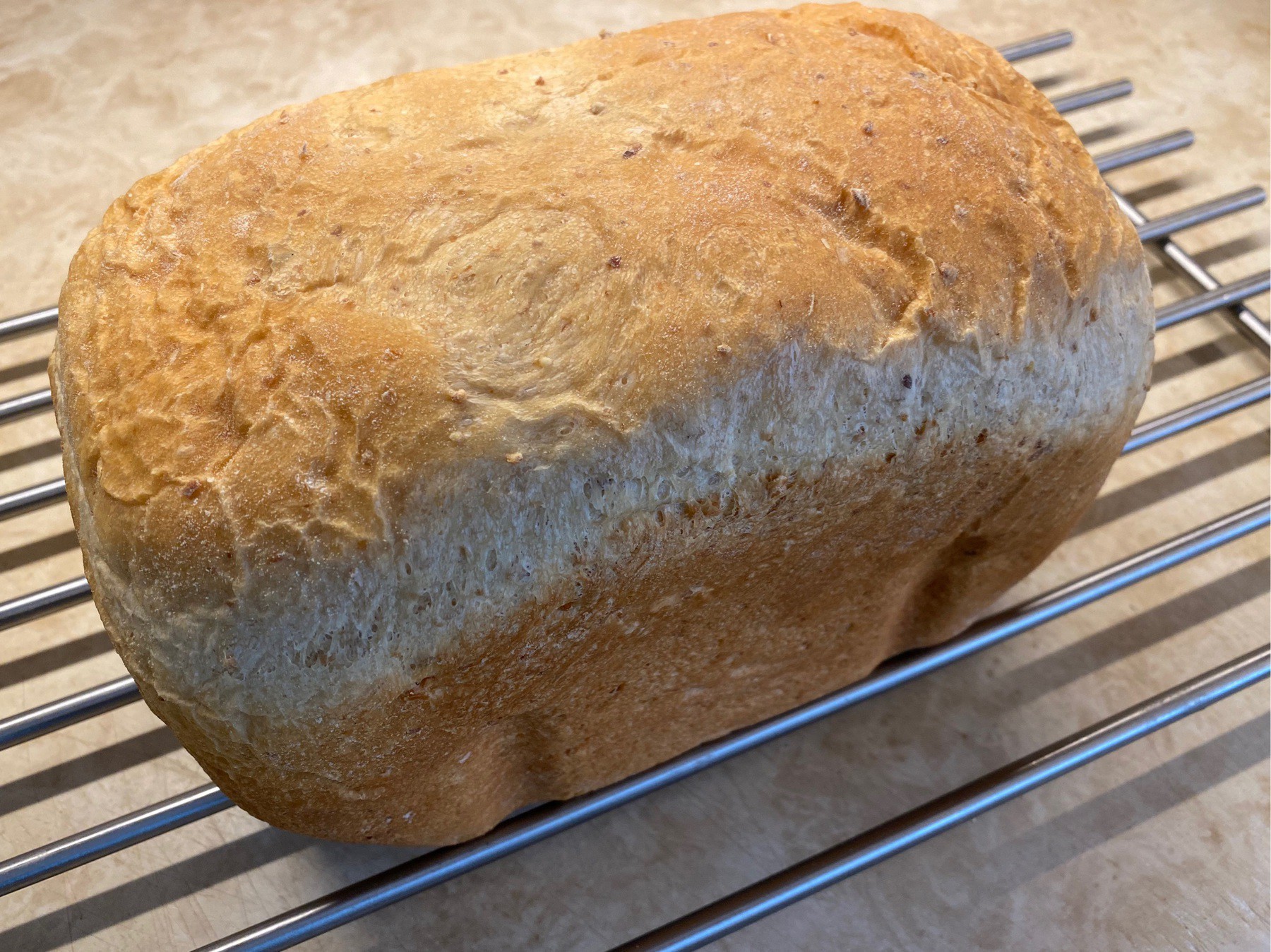 Loaf of bread cooling on rack.