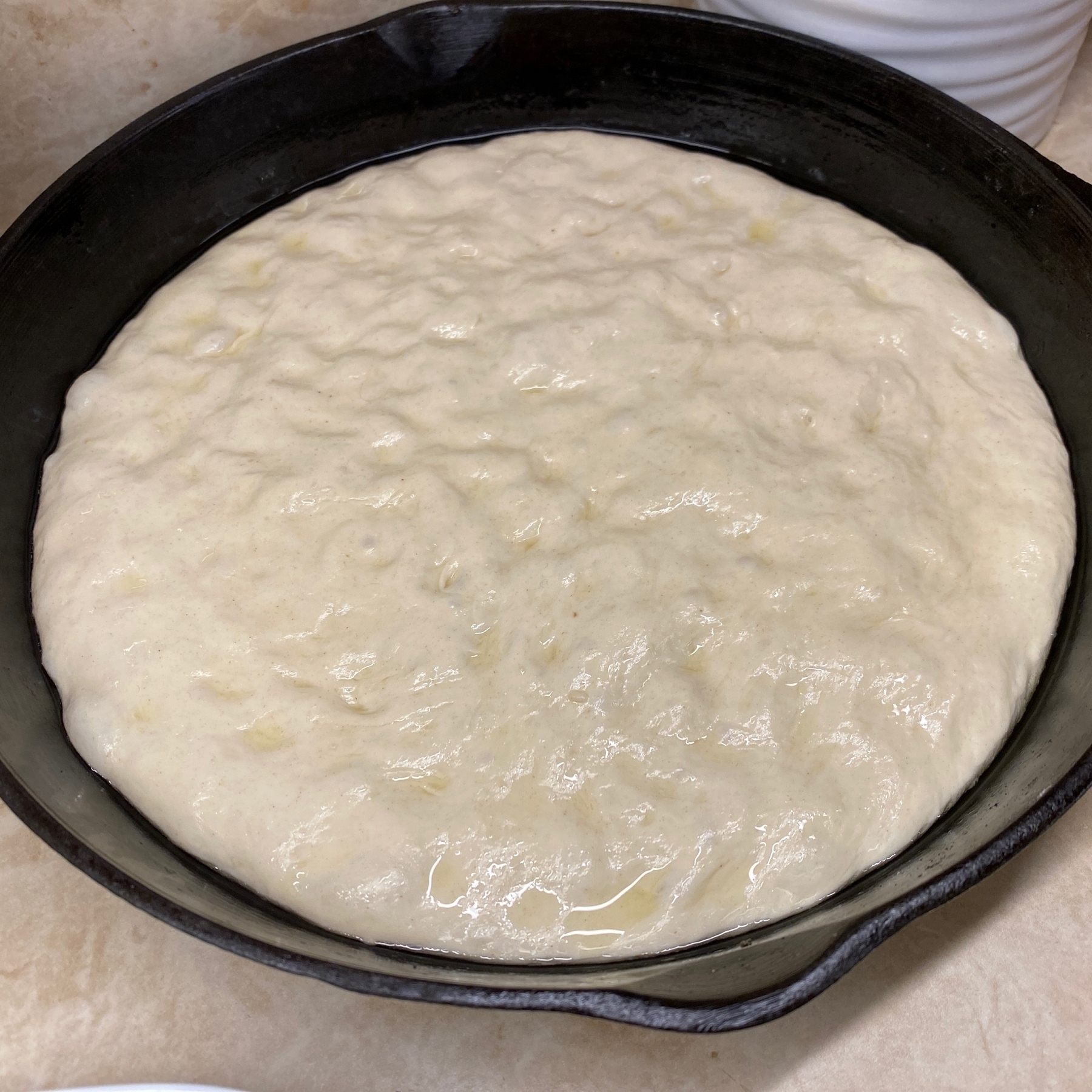 Pizza dough in cast iron pan.