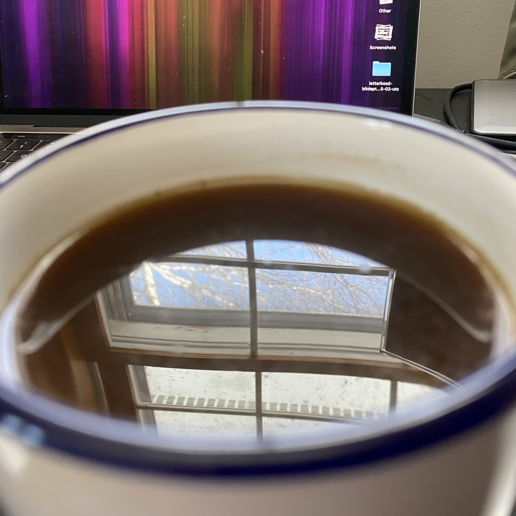 Window reflected in coffee in mug.