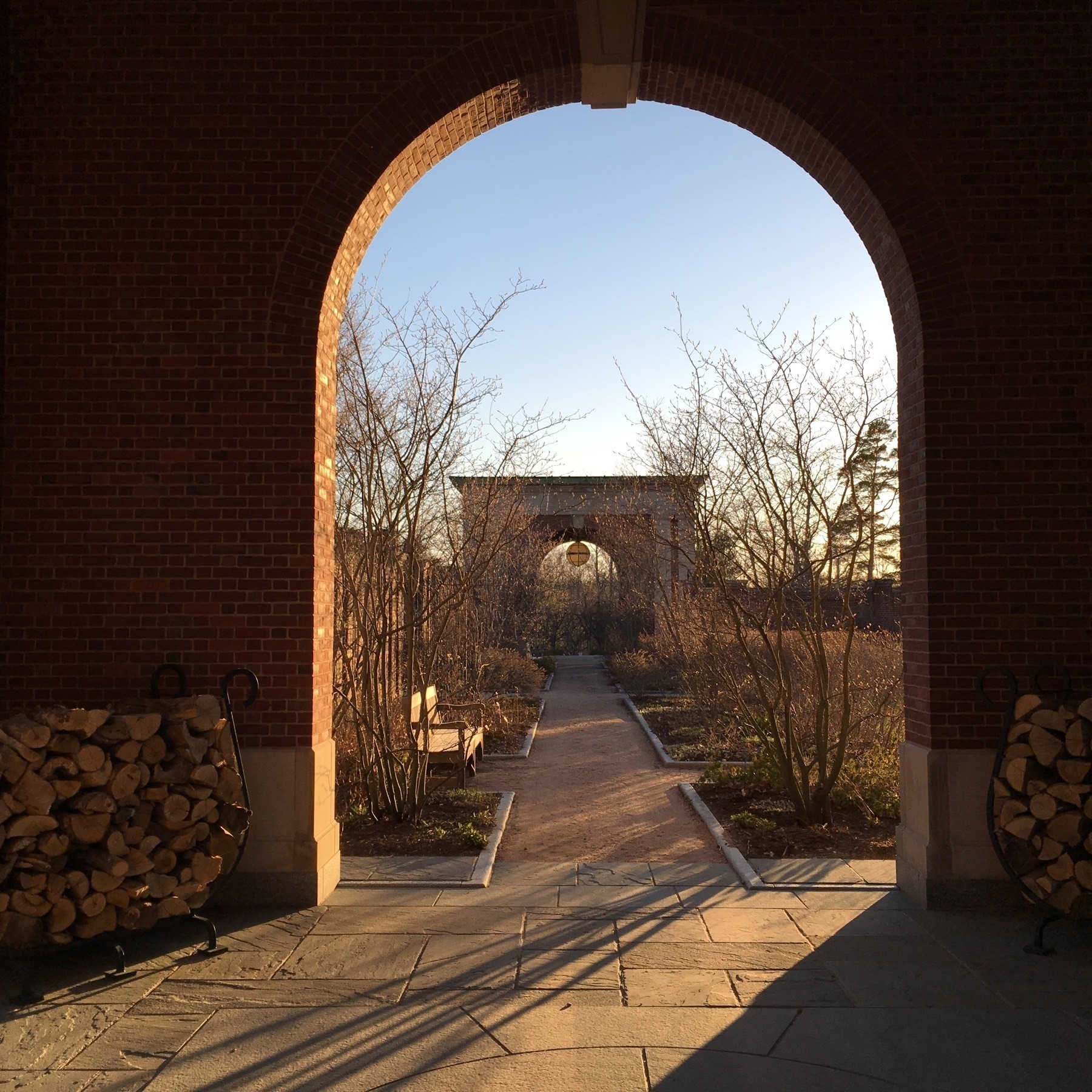 Archway with evening sun shining through with botanical garden in the distance. 