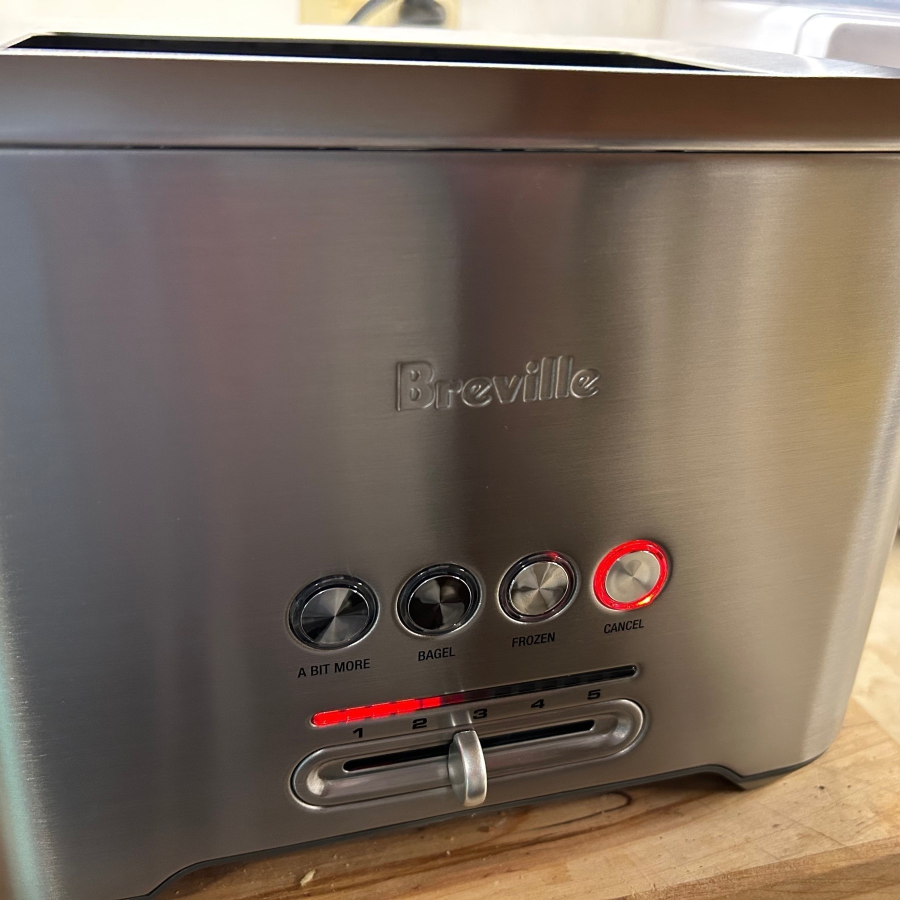 Metal toaster with red lights in a line indicating time remaining for toasting. 