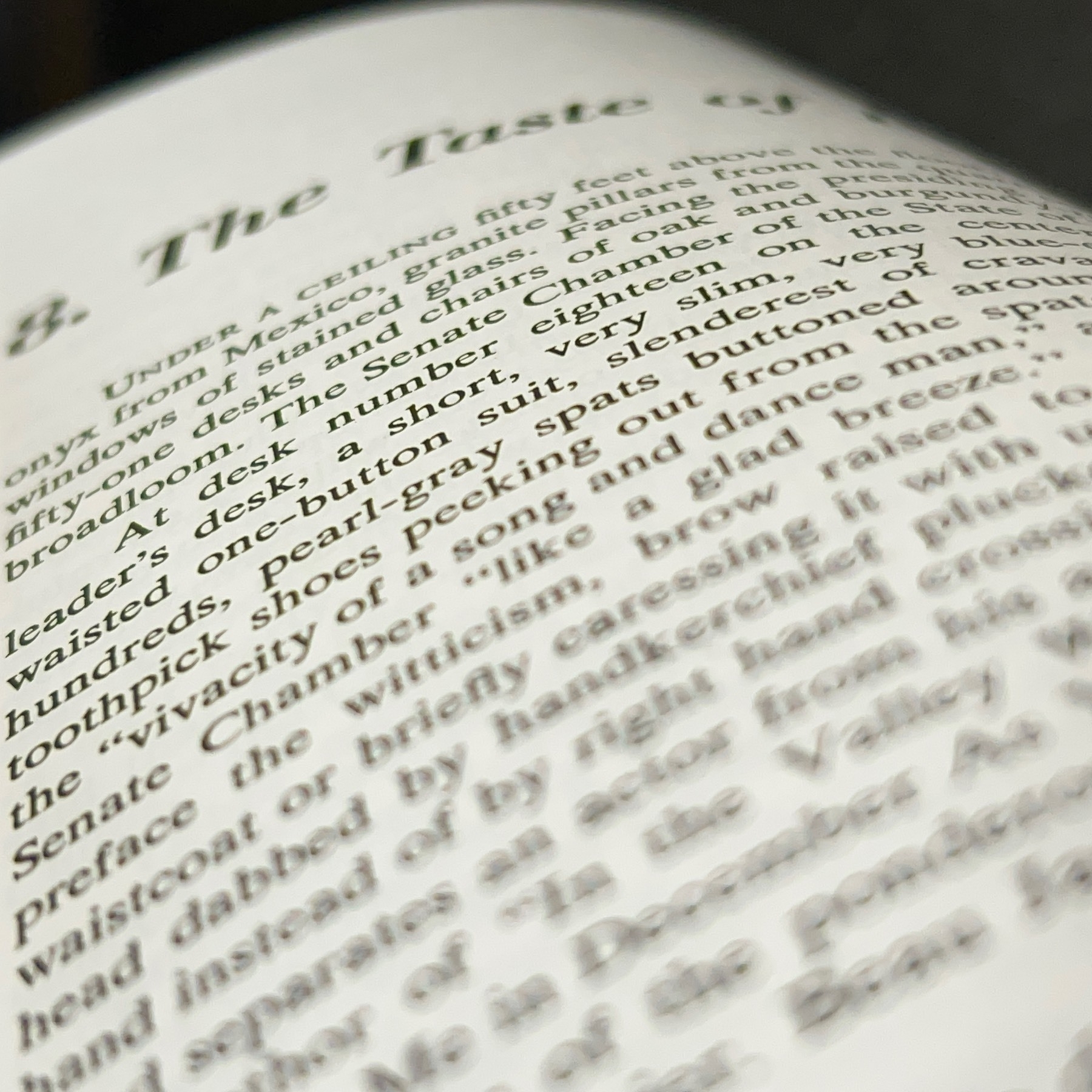 Close and angled photo of a page of text from a book with most of the text out of focus.
