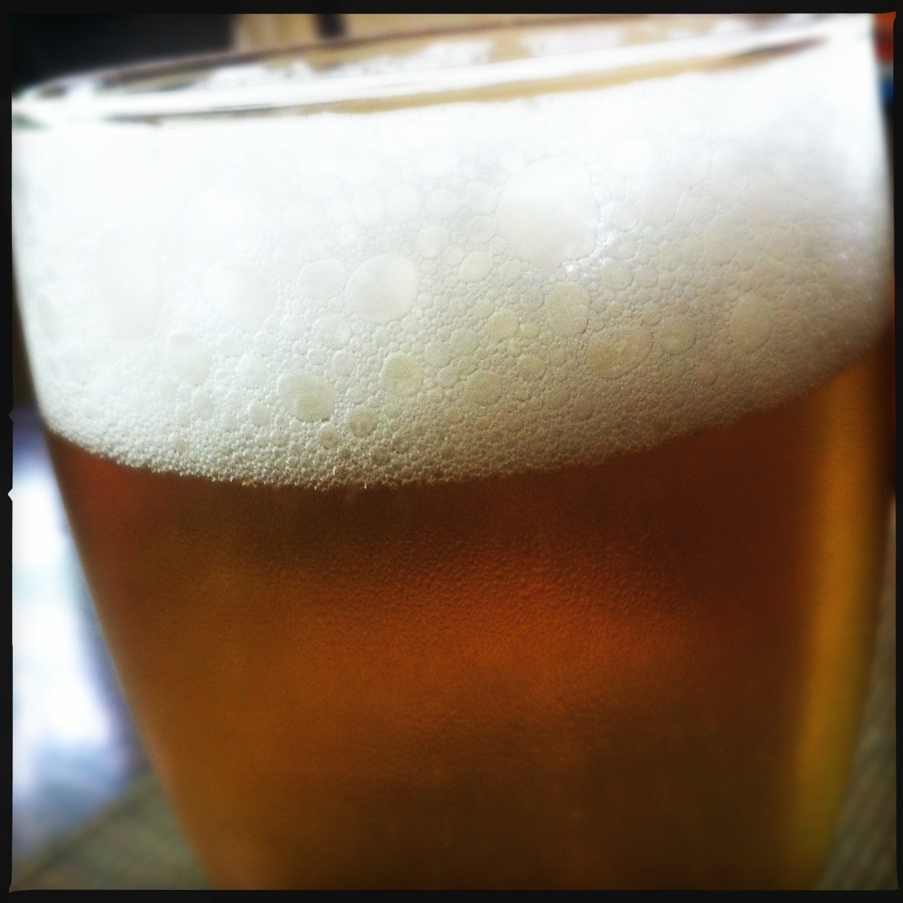 Head of foam at the top of a glass of beer in a glass. 