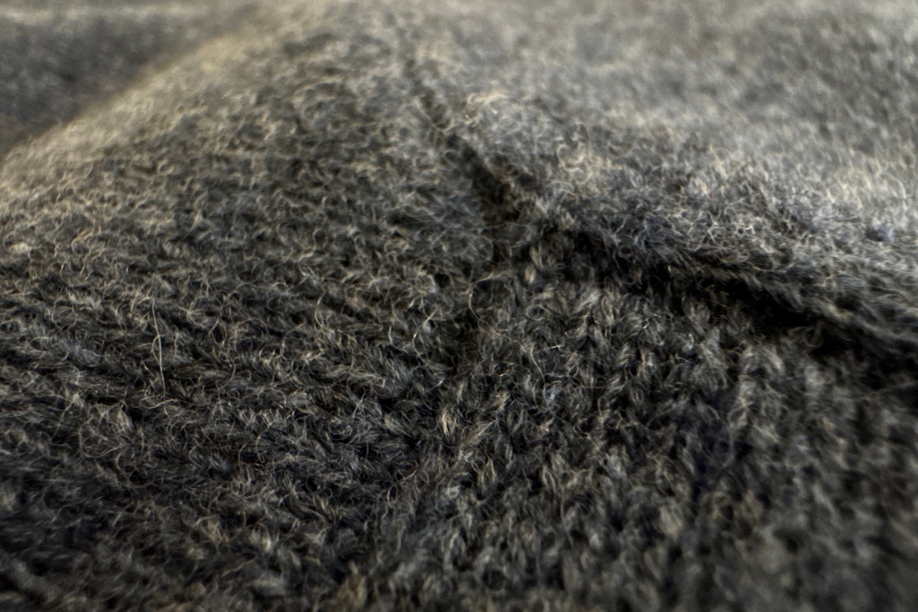 Lines is stitching on a blue wool sweater. 