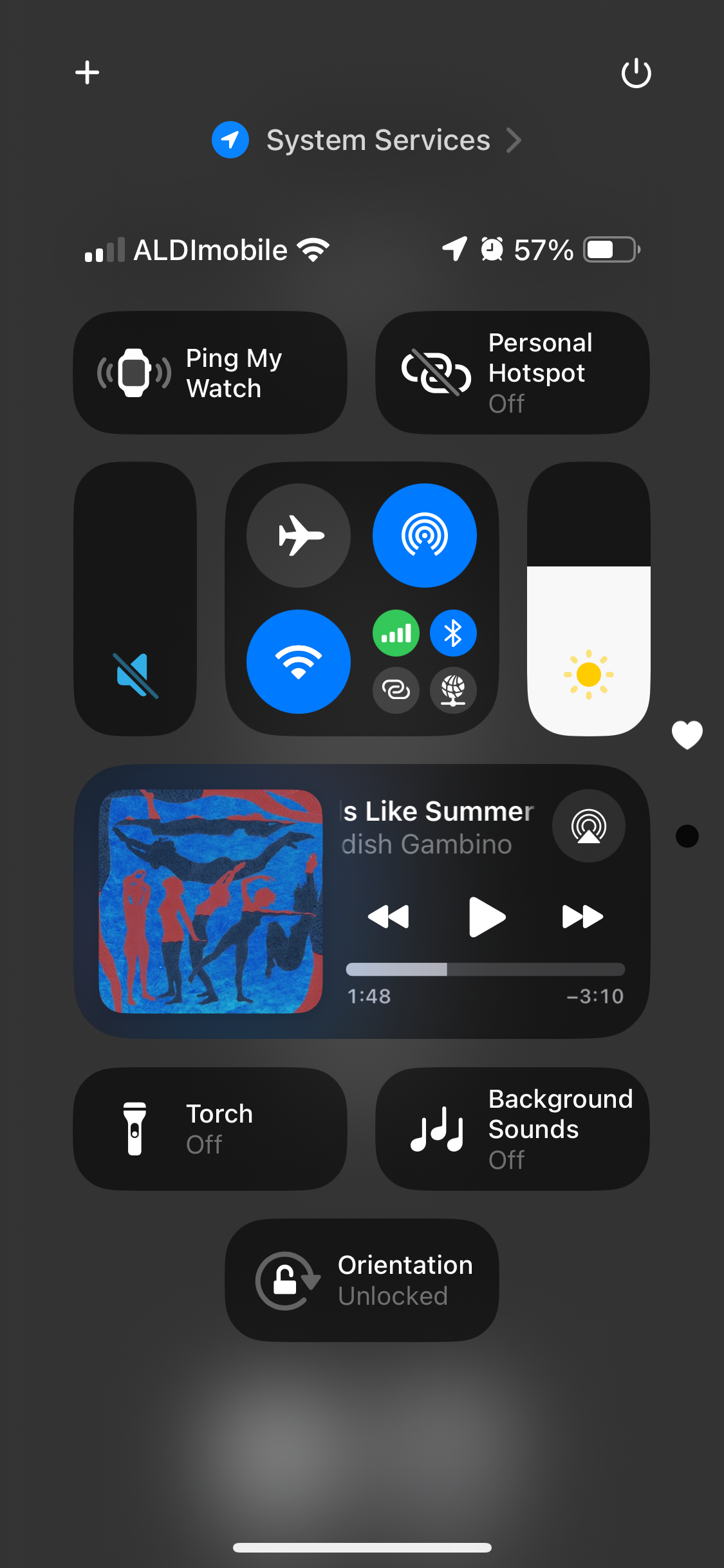 Screenshot of iOS Control Center showing various toggles and settings. The top section shows cellular signal and Wi-Fi status with the 57% battery remaining icon. A song by a named artist is playing with a colorful album cover visible. Other options include Ping My Watch, Personal Hotspot (Off), and controls for airplane mode, Wi-Fi, and Bluetooth. Brightness slider and play/pause controls for music are also visible. Below, there are toggles for Torch, Background Sounds, and Orientation (unlocked).