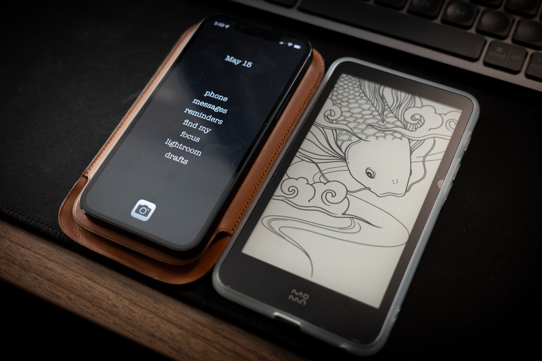 Auto-generated description: Two smartphones are placed side by side, one displaying a clock and text, and the other showing an intricate fish illustration.