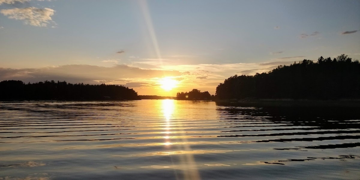 sun setting over a lake in finland